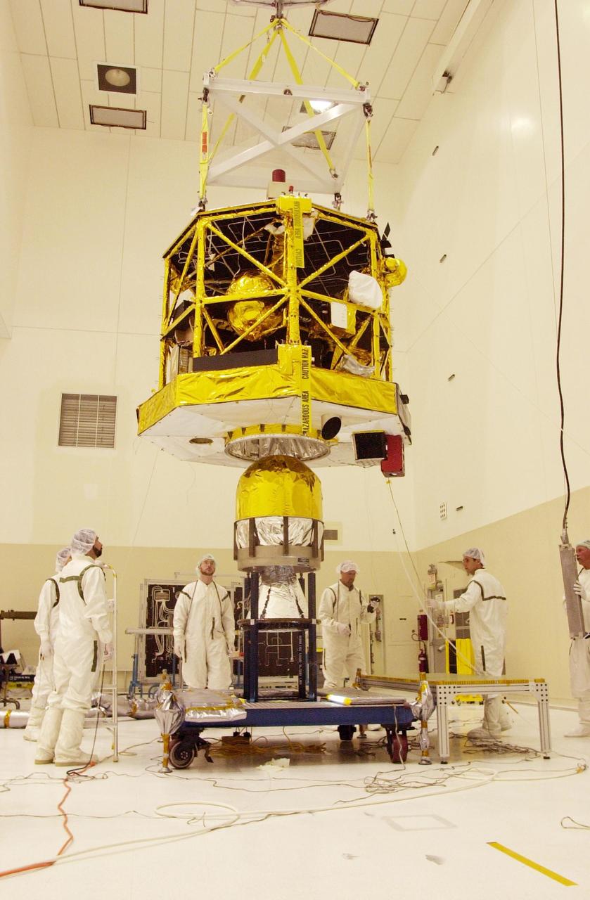 KENNEDY SPACE CENTER, FLA. -- In the Spacecraft Assembly and Encapsulation Facility 2, workers watch closely as the CONTOUR spacecraft is lowered toward the apogee kick motor to which it will be attached. CONTOUR will provide the first detailed look into the heart of a comet -- the nucleus. The spacecraft will fly close to at least two comets, Encke and Schwassmann-Wachmann 3, taking pictures of the nucleus while analyzing the gas and dust that surround these rocky, icy building blocks of the solar system. The Applied Physics Laboratory of Johns Hopkins University, Baltimore, Md., built CONTOUR and will also be in control of the spacecraft after launch, scheduled for July 1, 2002, from LC 17A at Cape Canaveral Air Force Station