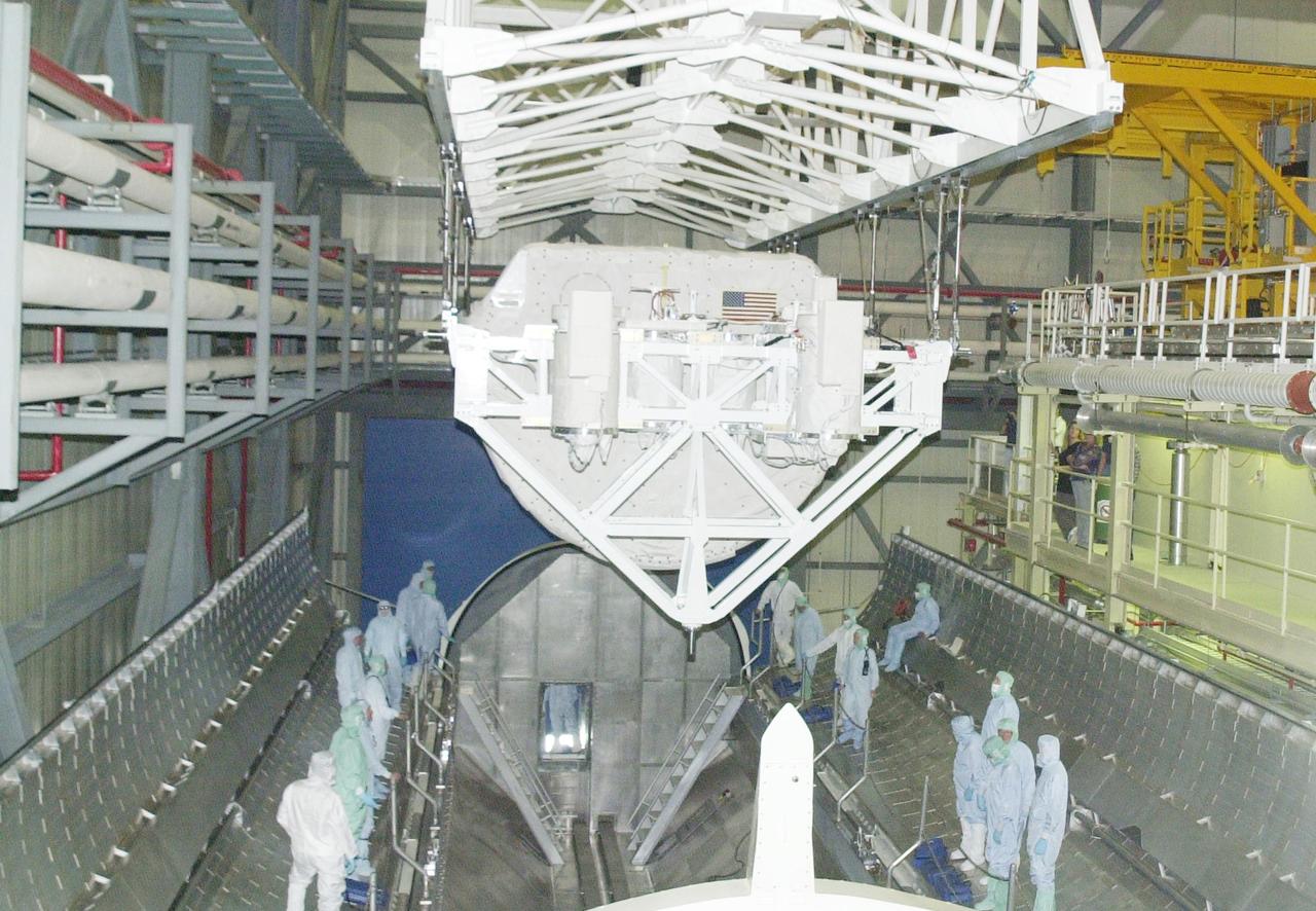 KENNEDY SPACE CENTER, FLA. -- In the Orbiter Processing Facility, the SHI Research Double Module (SHI/RDM) and Hitchhiker Carrier behind it are suspended by an overhead crane during their move to Columbia's payload bay. SHI/RDM is the primary payload of the STS-107 research mission, with experiments ranging from material sciences to life sciences (many rats). Also, the Fast Reaction Experiments Enabling Science, Technology, Applications and Research (FREESTAR) that is on the Hitchhiker Carrier incorporates eight high priority secondary attached shuttle experiments. STS-107 is scheduled to launch July 19, 2002