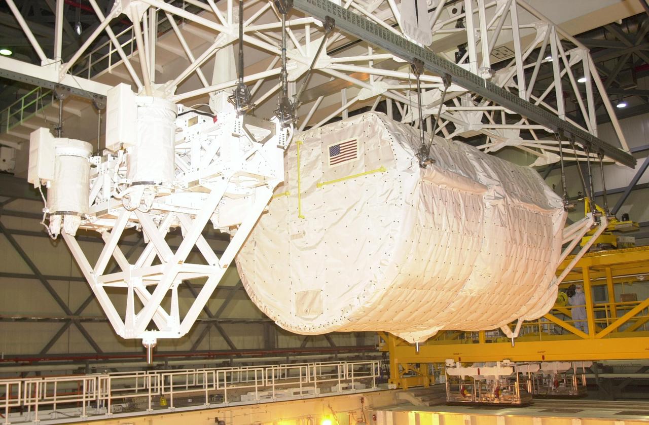 KENNEDY SPACE CENTER, FLA. -- The SHI Research Double Module (SHI/RDM) (right) and Hitchhiker Carrier (left) are lowered toward Columbia's payload bay. The two payloads will be installed in the payload bay for mission STS-107, a research mission. SHI/RDM is the primary payload, with experiments ranging from material sciences to life sciences (many rats). Also, the Fast Reaction Experiments Enabling Science, Technology, Applications and Research (FREESTAR) that is on the Hitchhiker Carrier incorporates eight high priority secondary attached shuttle experiments. STS-107 is scheduled to launch July 19, 2002