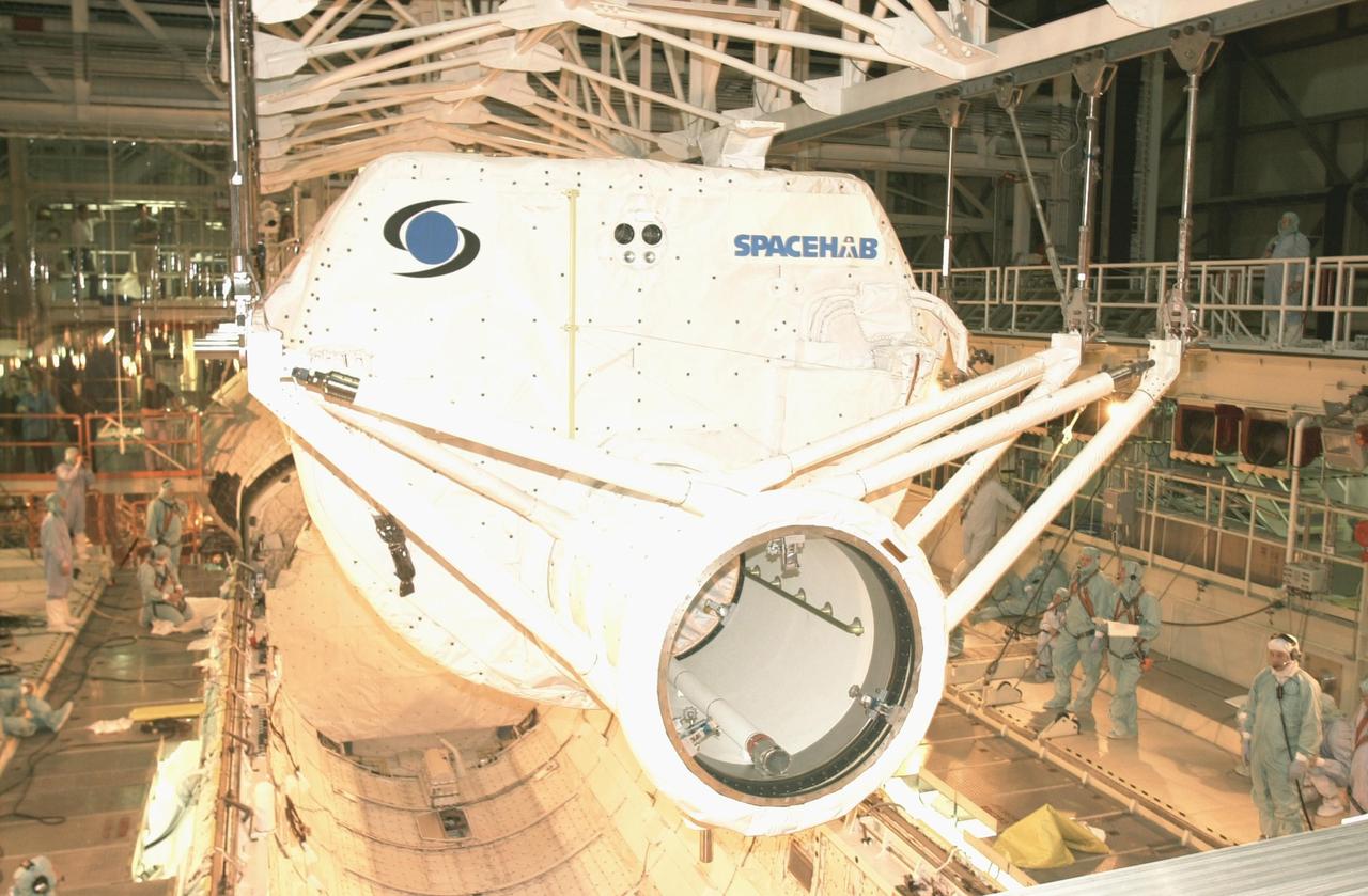 KENNEDY SPACE CENTER, FLA. -- The SHI Research Double Module (SHI/RDM) (right) and Hitchhiker Carrier (left) are lowered toward Columbia's payload bay. The two payloads will be installed in the payload bay for mission STS-107, a research mission. SHI/RDM is the primary payload, with experiments ranging from material sciences to life sciences (many rats). Also, the Fast Reaction Experiments Enabling Science, Technology, Applications and Research (FREESTAR) that is on the Hitchhiker Carrier incorporates eight high priority secondary attached shuttle experiments. STS-107 is scheduled to launch July 19, 2002