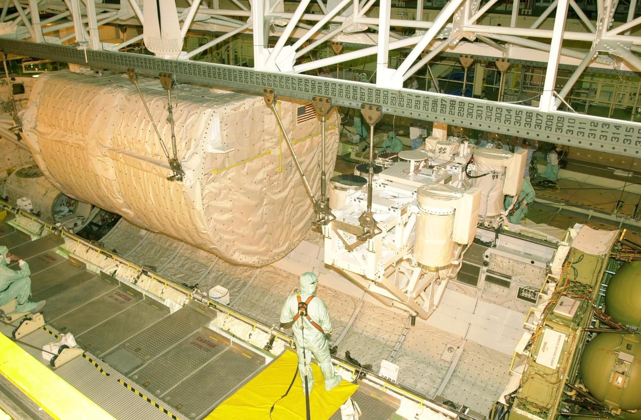 KENNEDY SPACE CENTER, FLA. -- The SHI Research Double Module (SHI/RDM) (left) and Hitchhiker Carrier (right) are lowered toward Columbia's payload bay. The two payloads will be installed in the payload bay for mission STS-107, a research mission. SHI/RDM is the primary payload, with experiments ranging from material sciences to life sciences (many rats). Also, the Fast Reaction Experiments Enabling Science, Technology, Applications and Research (FREESTAR) that is on the Hitchhiker Carrier incorporates eight high priority secondary attached shuttle experiments. STS-107 is scheduled to launch July 19, 2002
