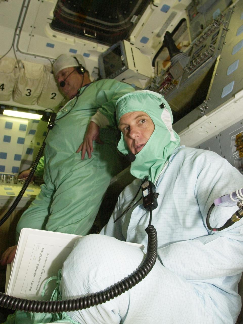 KENNEDY SPACE CENTER, FLA. -- Dressed in a bunny suit, STS-107 Payload Specialist Ilan Ramon, who is with the Israeli Space Agency, reviews data in Columbia's payload bay for Fast Reaction Experiments Enabling Science, Technology, Applications and Research (FREESTAR) experiments for the mission. FREESTAR comprises Mediterranean Israeli Dust, Solar Constant, Shuttle Ozone Limb Sounding, Critical Viscosity of Xenon,  Low Power, and Space Experimental Module experiments.  Another payload is the SHI Research Double Module (SHI/RDM), also known as SPACEHAB. The experiments range from material sciences to life sciences.  STS-107 is scheduled to launch July 11, 2002