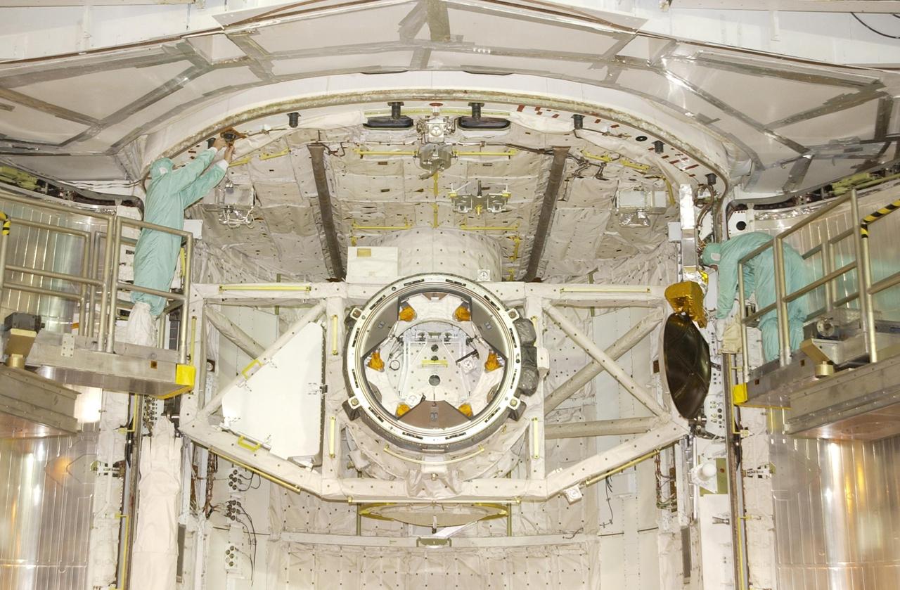 KENNEDY SPACE CENTER, FLA. --  Workers at Launch Pad 39A check the fittings on the payload bay of Endeavour before the bay doors close.  The view is looking down into the payload bay.  The Shuttle is poised for launch on mission STS-111, Utilization Flight 2, carrying supplies and equipment to the International Space Station. The payload includes the Multi-Purpose Logistics Module Leonardo, the Mobile Base System, which will be installed on the Mobile Transporter to complete the Canadian Mobile Servicing System, and a replacement wrist/roll joint for Canadarm 2.  Also part of the mission, Expedition 5 will travel to the Station as the replacement crew for Expedition 4, who will return to Earth aboard the orbiter.  Launch is scheduled for May 30, 2002