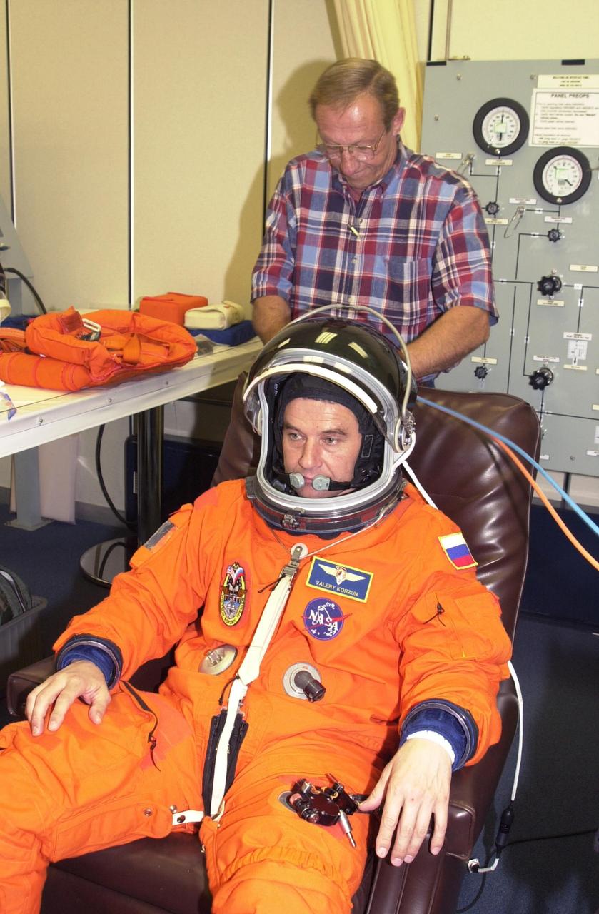 KENNEDY SPACE CENTER, FLA. - During suit check, part of pre-launch activities, Expedition 5 Commander Valeri Korzun gets help with his helmet.  Korzun is with the Russian Space Agency.  Part of Mission STS-111, Expedition 5 will travel to the International Space Station on Space Shuttle Endeavour as the replacement crew for Expedition 4, who will return to Earth aboard the orbiter.  The mission, known as Utilization Flight 2, is carrying supplies and equipment to the Station. The payload includes the Multi-Purpose Logistics Module Leonardo, the Mobile Base System, which will be installed on the Mobile Transporter to complete the Canadian Mobile Servicing System, or MSS, and a replacement wrist/roll joint for Canadarm 2. The mechanical arm will then have the capability to "inchworm" from the U.S. Lab Destiny to the MSS and travel along the truss to work sites. Launch is scheduled for May 30, 2002