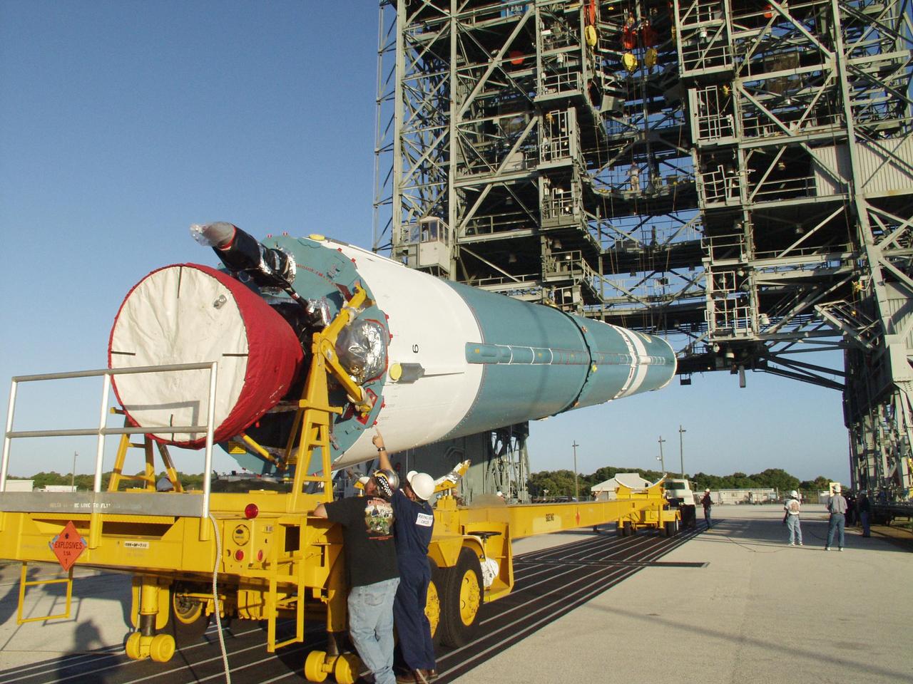 KENNEDY SPACE CENTER, FLA. - On Cape Canaveral Air Force Station Pad 17-A, workers check the lower portion of the Boeing Delta II rocket as it is lifted off the transporter. The rocket is the launch vehicle for the CONTOUR spacecraft, scheduled to launch July 1. CONTOUR will provide the first detailed look into the heart of a comet -- the nucleus. The spacecraft will fly close to at least two comets, Encke and Schwassmann-Wachmann 3, taking pictures of the nucleus while analyzing the gas and dust that surround these rocky, icy building blocks of the solar system.