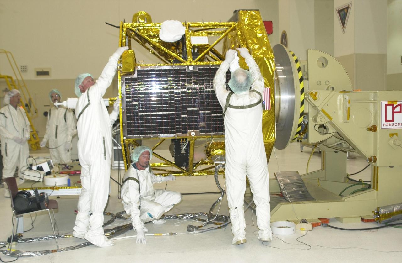 KENNEDY SPACE CENTER, FLA. -- Workers in the Spacecraft Assembly and Encapsulation Facility 2 install a solar panel on the Comet Nucleus Tour (CONTOUR) spacecraft. CONTOUR will provide the first detailed look into the heart of a comet -- the nucleus. The spacecraft will fly as close as 60 miles (100 kilometers) to at least two comets and will take the sharpest pictures yet of the nucleus while analyzing the gas and dust that surround these rocky, icy building blocks of the solar system. Launch of CONTOUR aboard a Boeing Delta II rocket is scheduled for July 1 from Launch Pad 17-A, Cape Canaveral Air Force Station