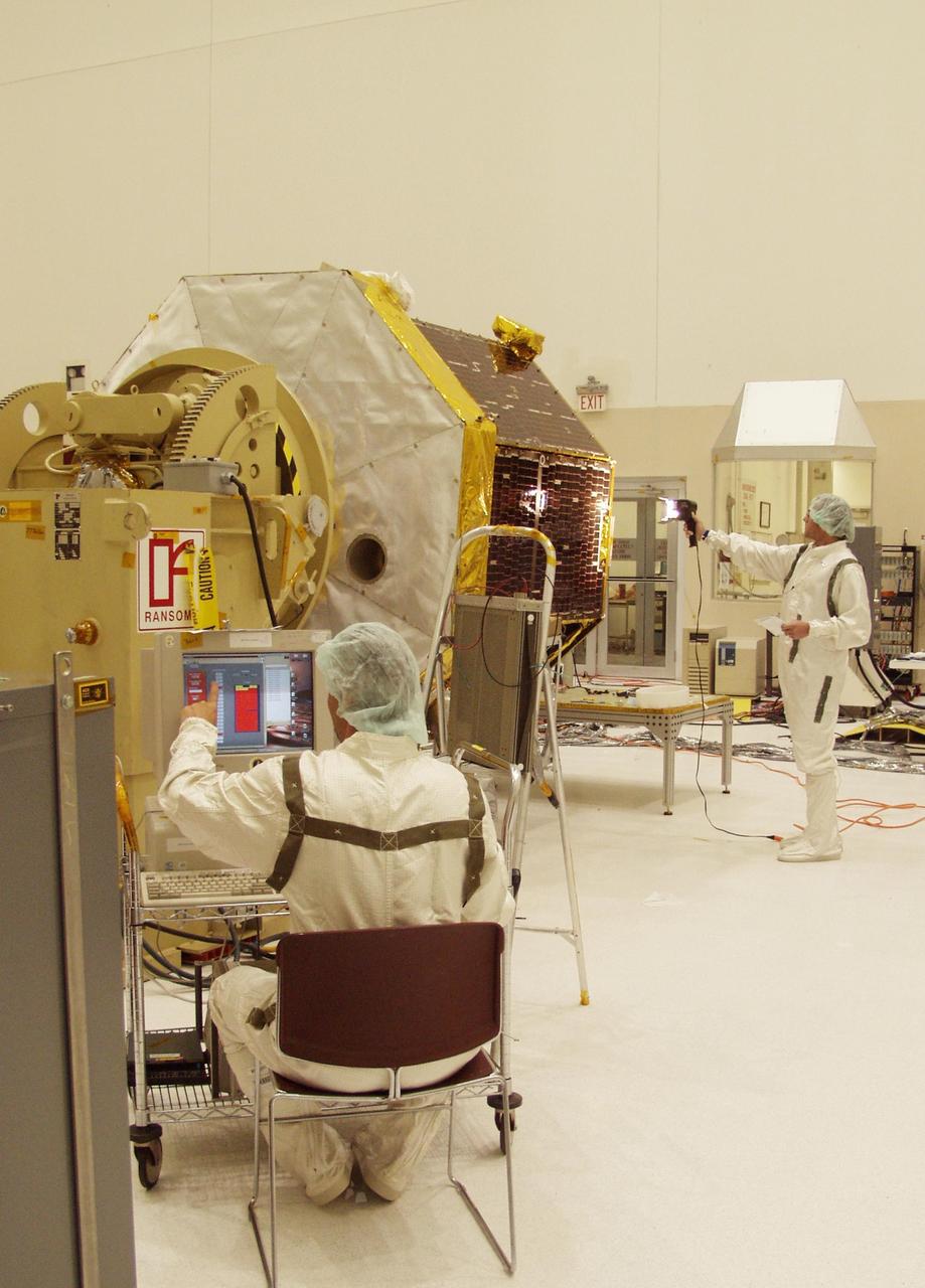 KENNEDY SPACE CENTER, FLA. -- In the Spacecraft Assembly and Encapsulation Facility 2,  technicians conduct a lighting test on the solar panels on the Comet Nucleus Tour (CONTOUR) spacecraft. The spacecraft will provide the first detailed look into the heart of a comet -- the nucleus. The spacecraft will fly as close as 60 miles (100 kilometers) to at least two comets and will take the sharpest pictures yet of the nucleus while analyzing the gas and dust that surround these rocky, icy building blocks of the solar system. Launch of CONTOUR aboard a Boeing Delta II rocket is scheduled for July 1 from Launch Pad 17-A, Cape Canaveral Air Force Station