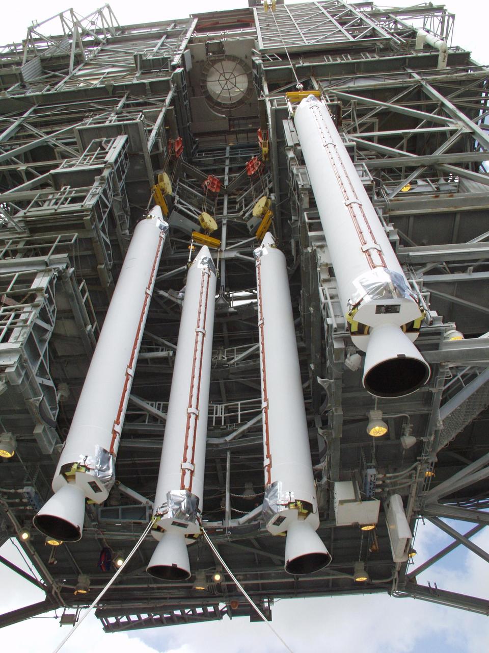 KENNEDY SPACE CENTER, FLA. -- On Launch Pad 17-A, Cape Canaveral Air Force Station, four solid rocket boosters are lifted for mating to a Boeing Delta II rocket. The rocket will be the launch vehicle for the CONTOUR spacecraft, scheduled to launch July 1. CONTOUR will provide the first detailed look into the heart of a comet -- the nucleus. The spacecraft will fly close to at least two comets, Encke and Schwassmann-Wachmann 3, taking pictures of the nucleus while analyzing the gas and dust that surround these rocky, icy building blocks of the solar system.