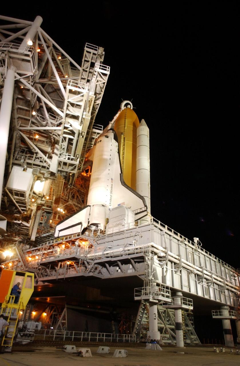 KENNEDY SPACE CENTER, FLA. - On Launch Pad 39A at 2:48 a.m. EDT, the Rotating Service Structure (left) begins rolling back from Space Shuttle Endeavour to allow launch preparations. At the lower left corner is seen the driver of one of the motor-driven trucks that move along circular twin rails installed flush with the pad surface. Endeavour rests on the Mobile Launcher Platform that straddles the flame trench below. The trench is 490 feet long, 58 feet wide and 40 feet high. STS-111 is the second Utilization Flight to the International Space Station, carrying the Multi-Purpose Logistics Module Leonardo, the Mobile Base System (MBS), and a replacement wrist/roll joint for the Canadarm 2. Also onboard Space Shuttle Endeavour is the Expedition 5 crew who will replace Expedition 4 on board the Station. The MBS will be installed on the Mobile Transporter to complete the Canadian Mobile Servicing System, or MSS. The mechanical arm will then have the capability to "inchworm" from the U.S. Lab Destiny to the MSS and travel along the truss to work sites. Expedition 4 crew members will return to Earth with the STS-111 crew on Endeavour. Launch is scheduled at 7:44 p.m. EDT, May 30, 2002