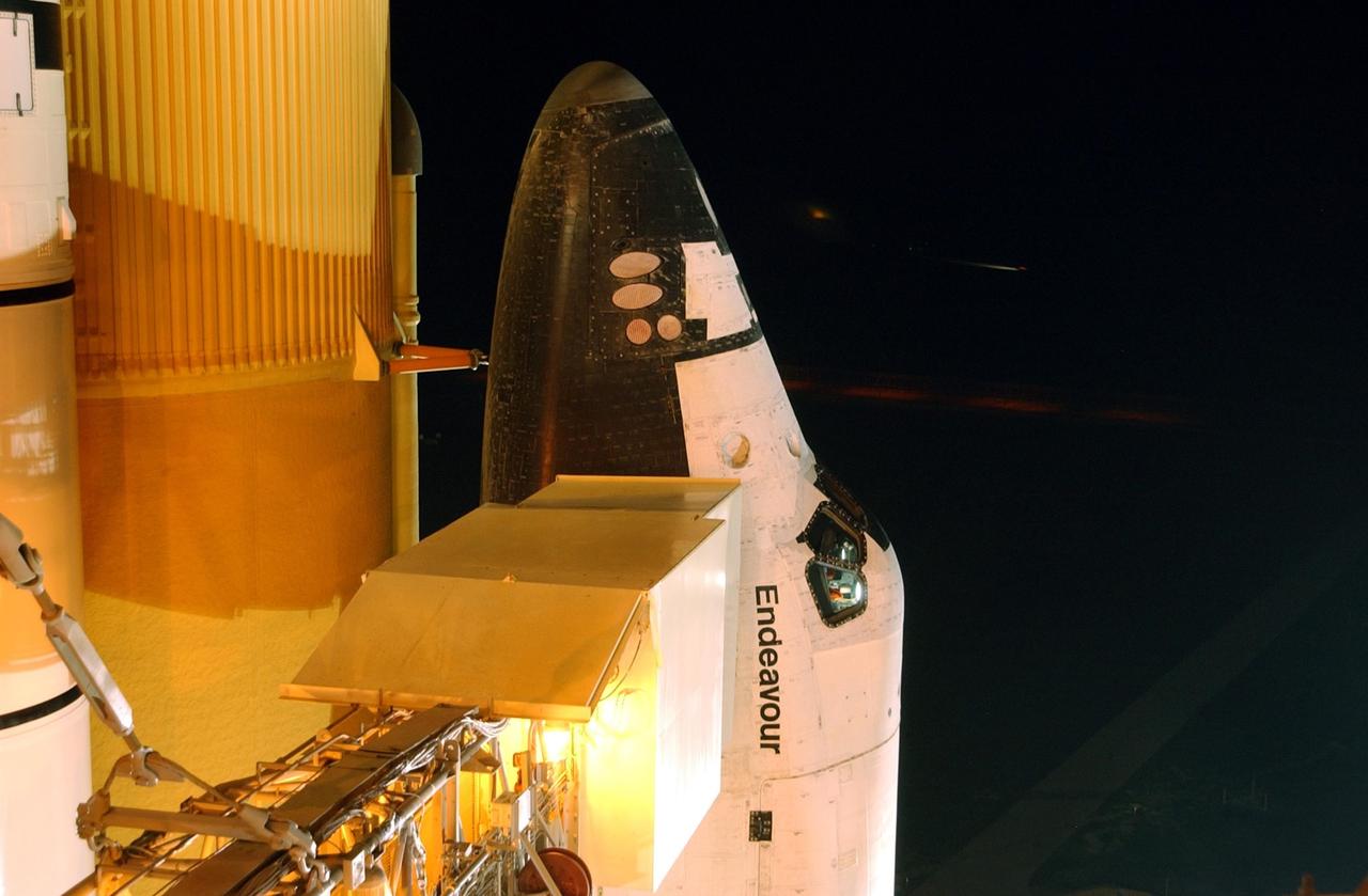 KENNEDY SPACE CENTER, FLA. - This closeup of Space Shuttle Endeavour shows the cockpit windows just above the name.  Extending to the side is the environmental chamber known as the White Room, at the end of the orbiter access arm. STS-111 is the second Utilization Flight to the International Space Station, carrying the Multi-Purpose Logistics Module Leonardo, the Mobile Base System (MBS), and a replacement wrist/roll joint for the Canadarm 2. Also onboard Space Shuttle Endeavour is the Expedition 5 crew who will replace Expedition 4 on board the Station. The MBS will be installed on the Mobile Transporter to complete the Canadian Mobile Servicing System, or MSS. The mechanical arm will then have the capability to "inchworm" from the U.S. Lab Destiny to the MSS and travel along the truss to work sites. Expedition 4 crew members will return to Earth with the STS-111 crew on Endeavour. Launch is scheduled for 7:44 p.m. EDT, May 30, 2002