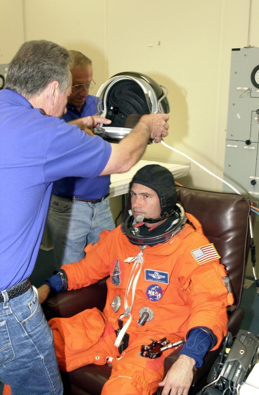 KENNEDY SPACE CENTER, FLA. - STS-111 Pilot Paul Lockhart waits for his helmet during suitup for the scheduled liftoff of Space Shuttle Endeavour at 7:44 p.m. EDT.  This is Lockhart's first Shuttle flight. STS-111 is the second Utilization Flight to the International Space Station, carrying the Multi-Purpose Logistics Module Leonardo, the Mobile Base System (MBS), and a replacement wrist/roll joint for the Canadarm 2. The MBS will be installed on the Mobile Transporter to complete the Canadian Mobile Servicing System, or MSS.  In addition, Expedition 5 is traveling on mission STS-111 to the International Space Station to replace the current resident crew, Expedition 4, who will return to Earth with the STS-111 crew
