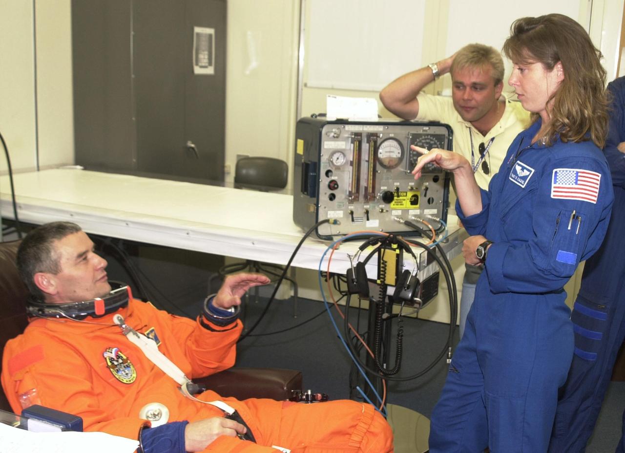 KENNEDY SPACE CENTER, FLA. -- Expedition 5 Commander Valeri Korzun (RSA), left, talks with astronaut Tracy Caldwell during suitup for the scheduled liftoff of Space Shuttle Endeavour at 7:44 p.m. EDT. This is Korzun's 2nd Shuttle flight. STS-111 is the second Utilization Flight to the International Space Station, carrying the Multi-Purpose Logistics Module Leonardo, the Mobile Base System (MBS), and a replacement wrist/roll joint for the Canadarm 2. The MBS will be installed on the Mobile Transporter to complete the Canadian Mobile Servicing System, or MSS. In addition, Expedition 5 is traveling on mission STS-111 to the International Space Station to replace the current resident crew, Expedition 4, who will return to Earth with the STS-111 crew