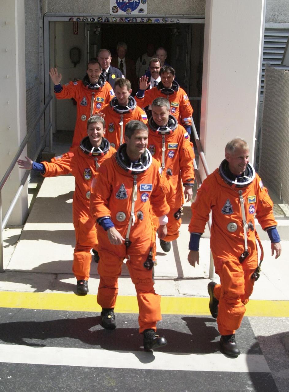 KENNEDY SPACE CENTER, FLA. -  The STS-111 and Expedition 5 crews eagerly stride from the Operations and Checkout Building toward the waiting Astrovan that will take them to Launch Pad 39A and Space Shuttle Endeavour.  From front to back are Pilot Paul Lockhart and Commander Kenneth Cockrell; astronaut Peggy Whitson and Expedition 5 Commander Valeri Korzun (RSA); cosmonaut Sergei Treschev (RSA); and Mission Specialists Philippe Perrin (CNES) and Franklin Chang-Diaz.  STS-111 is the second Utilization Flight to the International Space Station, carrying the Multi-Purpose Logistics Module Leonardo, the Mobile Base System (MBS), and a replacement wrist/roll joint for the Canadarm 2. Also onboard Space Shuttle Endeavour is the Expedition 5 crew who will replace Expedition 4 on board the Station. The MBS will be installed on the Mobile Transporter to complete the Canadian Mobile Servicing System, or MSS. The mechanical arm will then have the capability to "inchworm" from the U.S. Lab Destiny to the MSS and travel along the truss to work sites. Expedition 4 crew members will return to Earth with the STS-111 crew on Endeavour. 