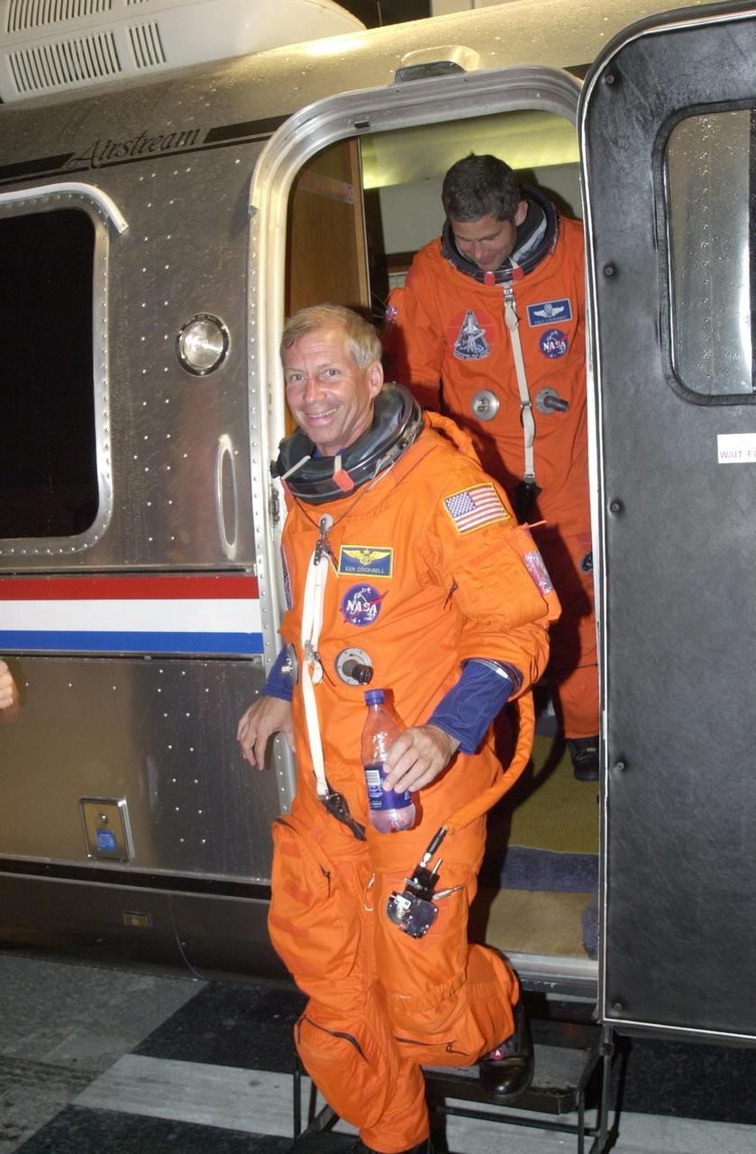 KENNEDY SPACE CENTER, FLA. - STS-111 Commander Kenneth Cockrell and Pilot Paul Lockhart step down from the Astrovan outside the crew quarters at the Operations and Checkout Building after returning from Space Shuttle Endeavour at Launch Pad 39A. The launch of STS-111 was scrubbed due to poor weather at KSC. STS-111 is the second Utilization Flight to the International Space Station, carrying the Multi-Purpose Logistics Module Leonardo, the Mobile Base System (MBS), and a replacement wrist/roll joint for the Canadarm 2. Also on board will be the Expedition Five crew who will replace Expedition Four on the Station. Launch is rescheduled for May 31 at 7:22 p.m. EDT