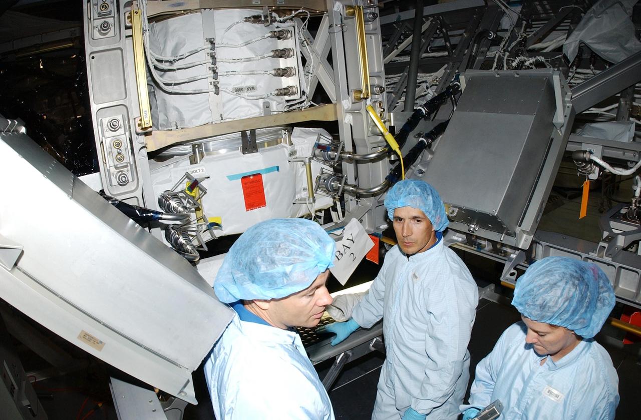 KENNEDY SPACE CENTER, FLA. - STS-113 Mission Specialists Michael Lopez-Alegria (left) and John Herrington (center) review data on the P1 Integrated Truss Structure with a technician in the Space Station Processing Facility. During the mission, the P1 truss will be attached to the central truss segment, S0 Truss, during spacewalks. The payload also includes the Crew and Equipment Translation Aid (CETA) Cart B that can be used by spacewalkers to move along the truss with equipment. STS-113 is scheduled to launch Oct. 6, 2002.