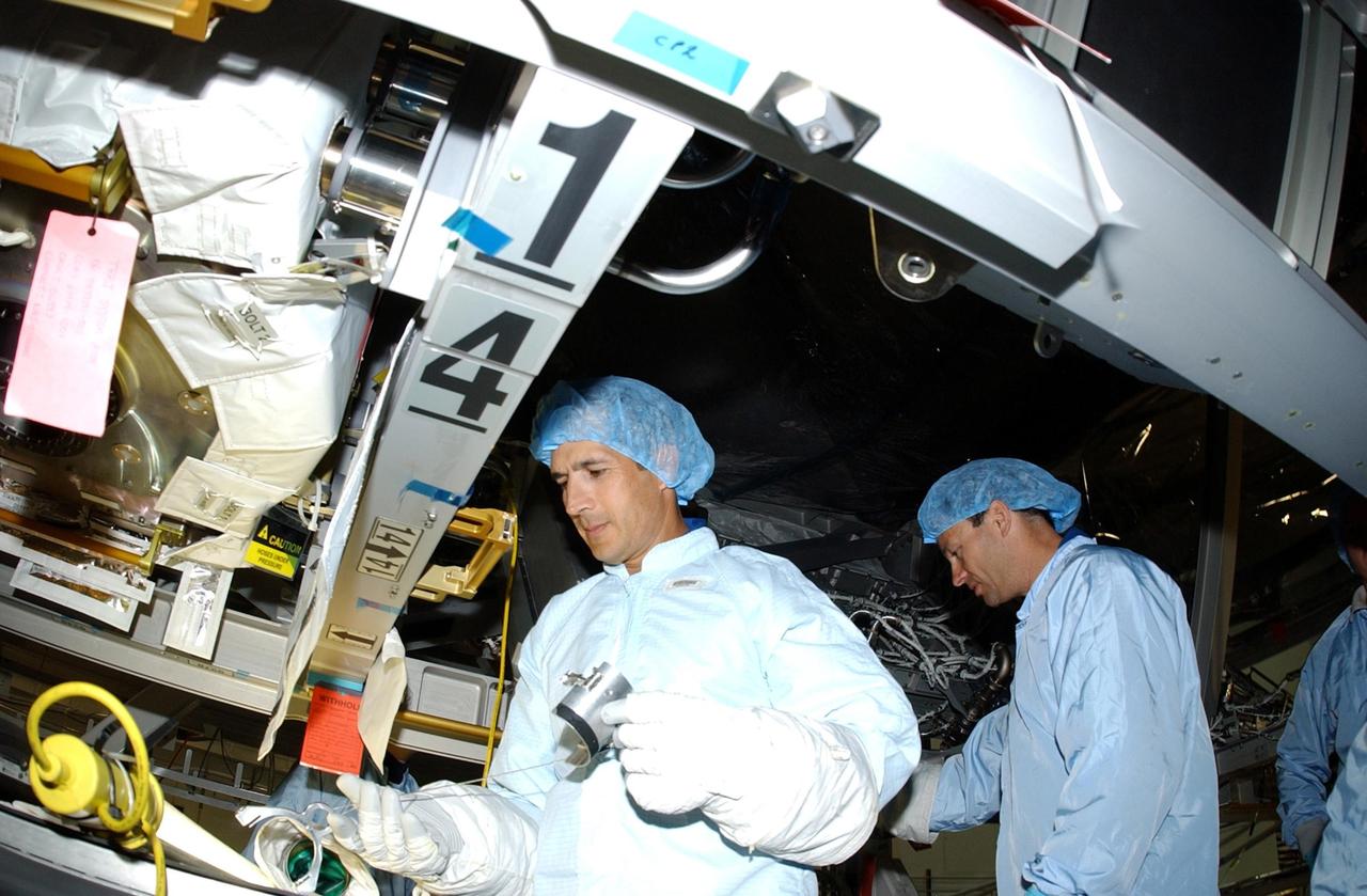 KENNEDY SPACE CENTER, FLA. -- STS-113 Mission Specialists John Herrington (left) and Michael Lopez-Alegria (right) look over the P1 Integrated Truss Structure, the primary payload for the mission. The P1 truss will be attached to the central truss segment, S0 Truss, during spacewalks. The payload also includes the Crew and Equipment Translation Aid (CETA) Cart B that can be used by spacewalkers to move along the truss with equipment. STS-113 is scheduled to launch Oct. 6, 2002