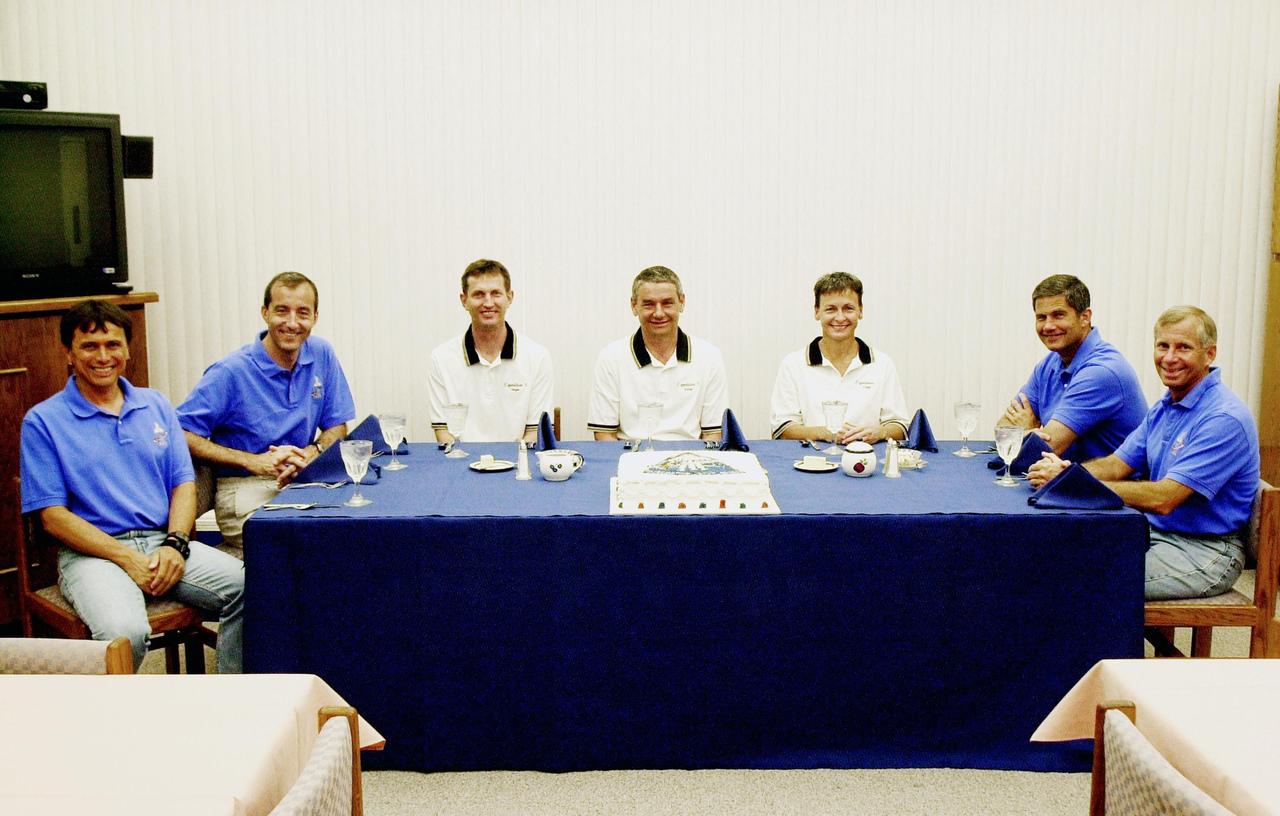 KENNEDY SPACE CENTER, FLA. --  The STS-111 crew gather for the traditional pre-launch meal before the second launch attempt aboard Space Shuttle Endeavour. Seated left to right are Mission Specialists Franklin Chang-Diaz and Philippe Perrin (CNES); the Expedition 5 crew cosmonauts Sergei Treschev (RSA) and Valeri Korzun (RSA) and astronaut Peggy Whitson; Pilot Paul Lockhart and Commander Kenneth Cockrell.  In front of them is the traditional cake. This mission marks the 14th Shuttle flight to the International Space Station and the third Shuttle mission this year. Mission STS-111 is the 18th flight of Endeavour and the 110th flight overall in NASA's Space Shuttle program.  On mission STS-111, astronauts will deliver the Leonardo Multi-Purpose Logistics Module, the Mobile Base System (MBS), and the Expedition Five crew to the Space Station. During the seven days Endeavour will be docked to the Station, three spacewalks will be performed dedicated to installing MBS and the replacement wrist-roll joint on the Station's Canadarm2 robotic arm.  Liftoff is scheduled for 5:22 p.m. EDT from Launch Pad 39A