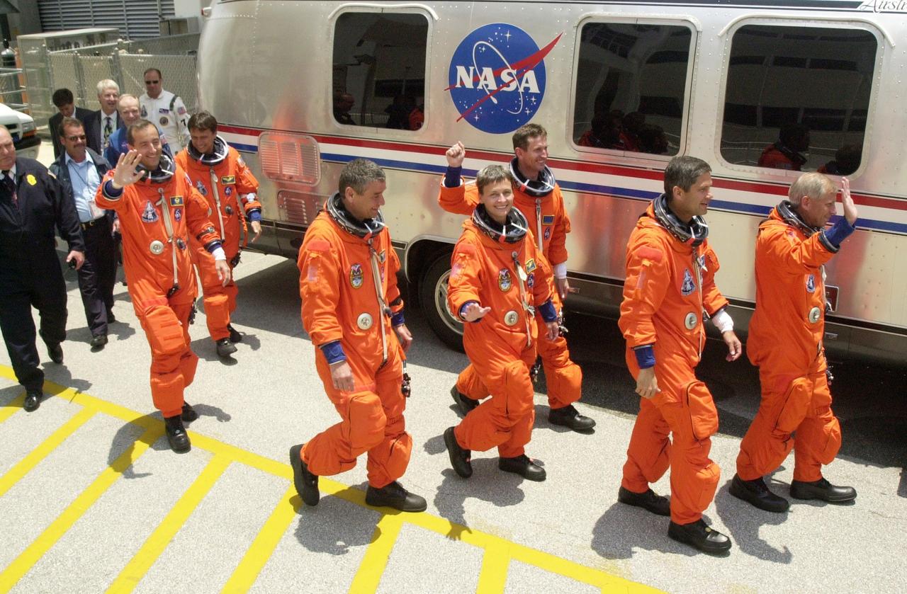 KENNEDY SPACE CENTER, FLA. -- The STS-111 and Expedition 5 crews head for the Astrovan to take them to Launch Pad 39A and the second launch attempt aboard Space Shuttle Endeavour.  From left to right, front to back, are Mission Specialists Philippe Perrin (CNES) and Franklin Chang-Diaz; Expedition 5 Commander Valeri Korzun, astronaut Peggy Whitson and cosmonaut Sergei Treschev; Pilot Paul Lockhart and Commander Kenneth Cockrell. This mission marks the 14th Shuttle flight to the Space Station and the third Shuttle mission this year. Mission STS-111 is the 18th flight of Endeavour and the 110th flight overall in NASA's Space Shuttle program.  On mission STS-111, astronauts will deliver the Leonardo Multi-Purpose Logistics Module, the Mobile Base System (MBS), and the Expedition Five crew to the Space Station. During the seven days Endeavour will be docked to the Station, three spacewalks will be performed dedicated to installing MBS and the replacement wrist-roll joint on the Station's Canadarm2 robotic arm. Endeavour will also carry the Expedition 5 crew, who will replace Expedition 4 on board the Station. Expedition 4 crew members will return to Earth with the STS-111 crew. Liftoff is scheduled for 5:22 p.m. EDT from Launch Pad 39A