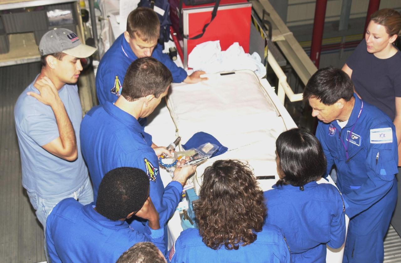 KENNEDY SPACE CENTER, FLA. -- During Crew Equipment Interface Test activities, the STS-107 crew looks at flight equipment in the Orbiter Processing Facility. Seen counter clockwise from top left are Pilot William "Willie" McCool, Commander Rick Husband, Payload Commander Michael Anderson, Mission Specialists Laurel Clark and Kalpana Chawla, and Payload Specialist Ilan Ramon, who is with the Israeli Space Agency. STS-107 is a research mission, with the SHI Research Double Module (SHI/RDM), also known as SPACEHAB, as the primary payload, plus the Fast Reaction Experiments Enabling Science, Technology, Applications and Research (FREESTAR) that incorporates eight high priority secondary attached shuttle experiments. STS-107 is scheduled to launch July 19, 2002