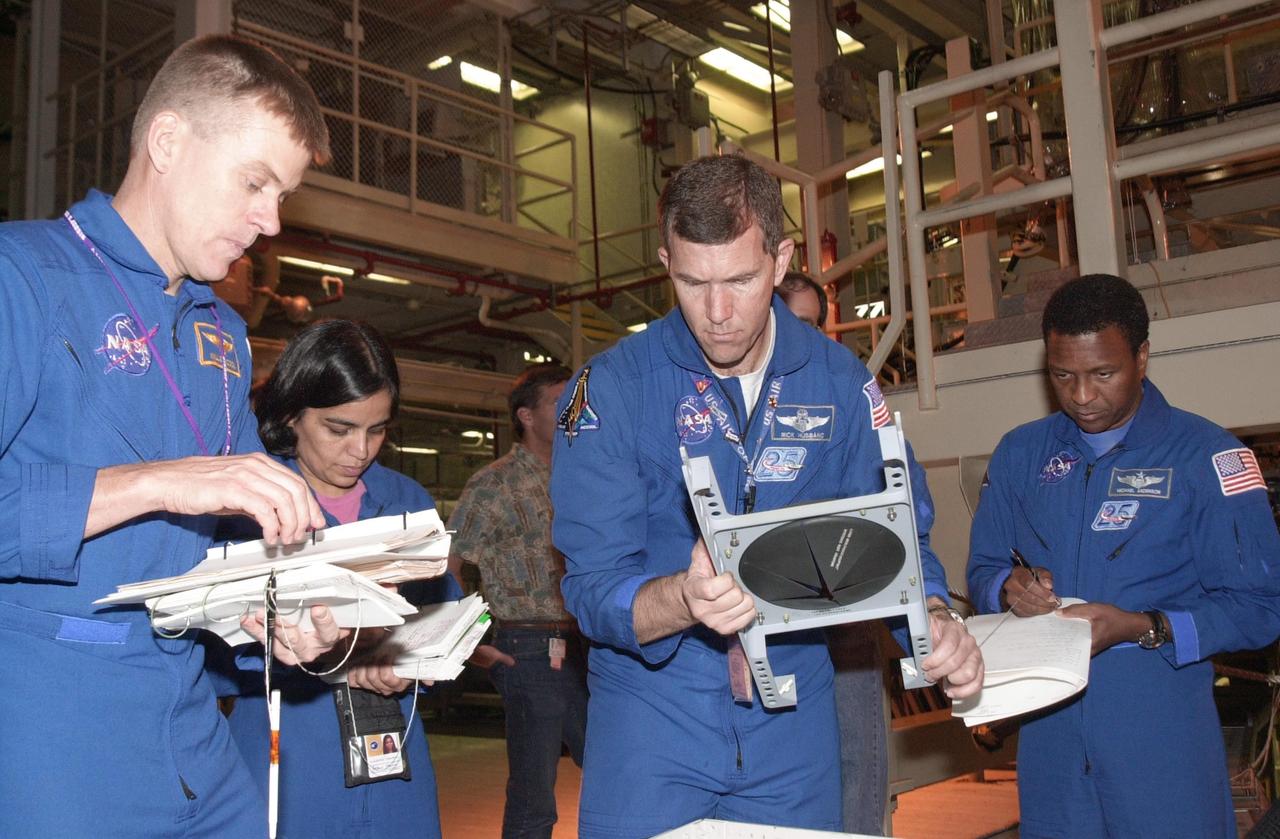 KENNEDY SPACE CENTER, FLA. -- -- During Crew Equipment Interface Test activities, the STS-107 crew looks at flight equipment in the Orbiter Processing Facility. From left are Pilot William "Willie" McCool, Mission Specialist Kalpana Chawla, Commander Rick Husband and Payload Commander Michael Anderson. STS-107 is a research mission, with the SHI Research Double Module (SHI/RDM), also known as SPACEHAB, as the primary payload, plus the Fast Reaction Experiments Enabling Science, Technology, Applications and Research (FREESTAR) that incorporates eight high priority secondary attached shuttle experiments. STS-107 is scheduled to launch July 19, 2002