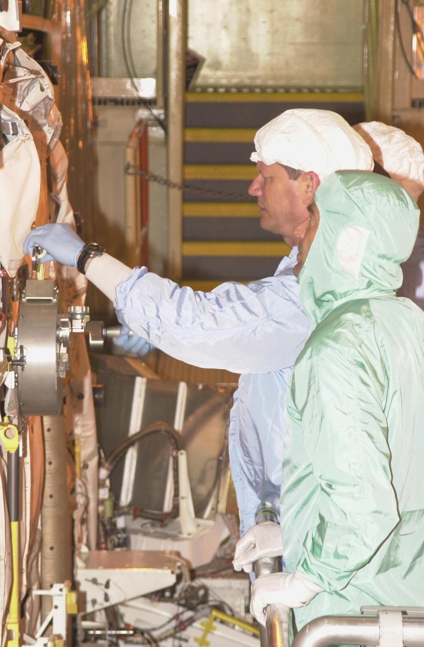 KENNEDY SPACE CENTER, FLA. - During Crew Equipment Interface Test activities,  STS-107 Mission Specialist David Brown checks equipment in the payload bay of  Columbia while a technician looks on.  Behind Brown is Payload Commander Michael Anderson. STS-107 is a research mission, with the SHI Research Double Module (SHI/RDM), also known as SPACEHAB, as the primary payload, plus the Fast Reaction Experiments Enabling Science, Technology, Applications and Research (FREESTAR) that incorporates eight high priority secondary attached shuttle experiments.  STS-107 is scheduled to launch July 19, 2002