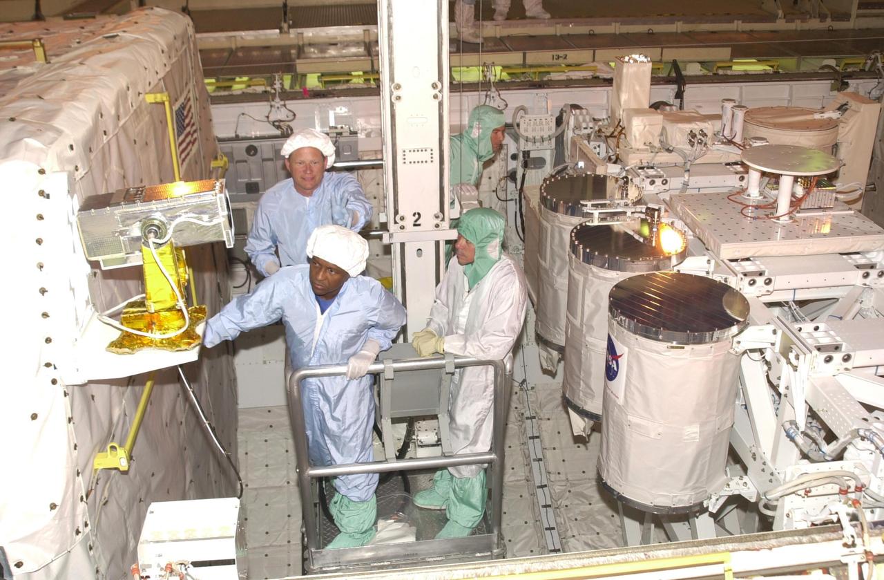 KENNEDY SPACE CENTER, FLA. -- During Crew Equipment Interface Test activities,  STS-107 Payload Commander Michael Anderson looks over equipment in the payload bay of Columbia.   Behind him is Mission Specialist David Brown. STS-107 is a research mission, with the SHI Research Double Module (SHI/RDM), also known as SPACEHAB, as the primary payload, plus the Fast Reaction Experiments Enabling Science, Technology, Applications and Research (FREESTAR) that incorporates eight high priority secondary attached shuttle experiments.  STS-107 is scheduled to launch July 19, 2002
