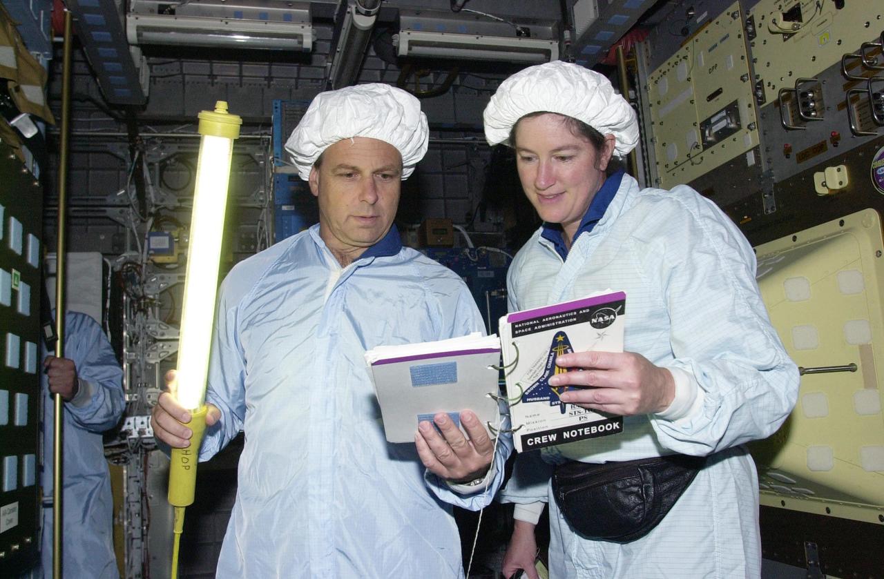 KENNEDY SPACE CENTER, FLA. -- STS-107 Mission Specialists Ilan Ramon, with the Israeli Space Agency, holds a light wand while he and Laurel Clark check out data for equipment in the SHI Research Double Module (SHI/RDM), part of the payload on the mission. They are taking part in Crew Equipment Interface Test activities, which include equipment and payload familiarization. A research mission, STS-107 also will carry the Fast Reaction Experiments Enabling Science, Technology, Applications and Research (FREESTAR) that incorporates eight high priority secondary attached shuttle experiments. STS-107 is scheduled to launch July 19, 2002