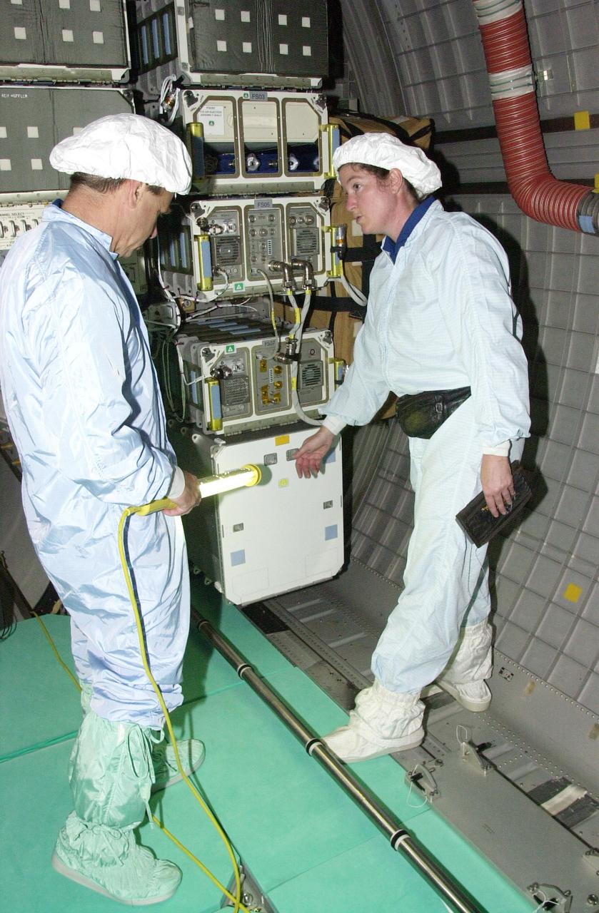 KENNEDY SPACE CENTER, FLA. -- STS-107 Mission Specialists Ilan Ramon, with the Israeli Space Agency, and Laurel Clark check out equipment in the SHI Research Double Module (SHI/RDM), part of the payload on the mission. They are taking part in Crew Equipment Interface Test activities, which include equipment and payload familiarization. A research mission, STS-107 also will carry the Fast Reaction Experiments Enabling Science, Technology, Applications and Research (FREESTAR) that incorporates eight high priority secondary attached shuttle experiments. STS-107 is scheduled to launch July 19, 2002