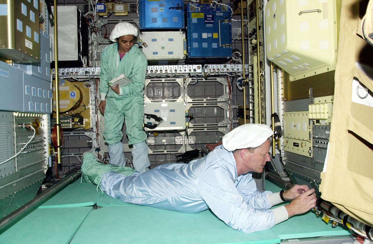 KENNEDY SPACE CENTER, FLA. -- STS-107 crew members check out equipment in the SHI Research Double Module (SHI/RDM), part of the payload on the mission. Mission Specialist Kalpana Chawla (left) holds a data manual while Mission Specialist David Brown stretches out on the floor to get a closer look. The crew is taking part in Crew Equipment Interface Test activities, which include equipment and payload familiarization. A research mission, STS-107 also will carry the Fast Reaction Experiments Enabling Science, Technology, Applications and Research (FREESTAR) that incorporates eight high priority secondary attached shuttle experiments. STS-107 is scheduled to launch July 19, 2002