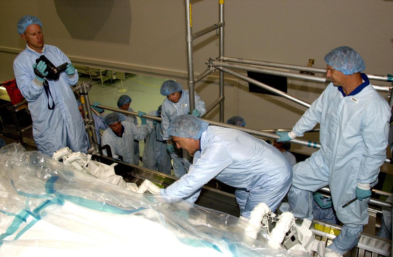 KENNEDY SPACE CENTER, FLA. -- In the Space Station Processing Facility, the STS-112 crew looks over the payload for their mission as part of the Crew Equipment Interface Test. At right are Mission Specialists David Wolf and Piers Sellers. Mission STS-112 will be ferrying the S1 ITS to the International Space Station on its scheduled Aug. 22 flight. The S1 truss is the first starboard (right-side) truss segment, whose main job is providing structural support for the orbiting research facility's radiator panels that cool the Space Station's complex power system. The S1 truss segment also will house communications systems, external experiment positions and other subsystems. The S1 truss will be attached to the S0 truss