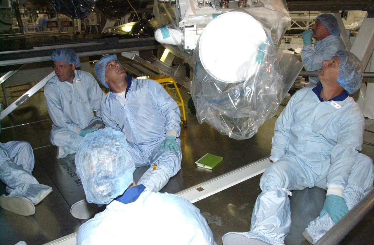 KENNEDY SPACE CENTER, FLA. -- In the Space Station Processing Facility, as part of the Crew Equipment Interface Test, the STS-112 crew get a different view of the mission payload. from underneath. Second from left is Mission Specialist David Wolf; at right are Mission Specialists Piers Sellers (front) and Fyodor Yurchikhin (back), who is with the Russian Space Agency. Mission STS-112 will be ferrying the S1 ITS to the International Space Station on its scheduled Aug. 22 flight. The S1 truss is the first starboard (right-side) truss segment, whose main job is providing structural support for the orbiting research facility's radiator panels that cool the Space Station's complex power system. The S1 truss segment also will house communications systems, external experiment positions and other subsystems. The S1 truss will be attached to the S0 truss