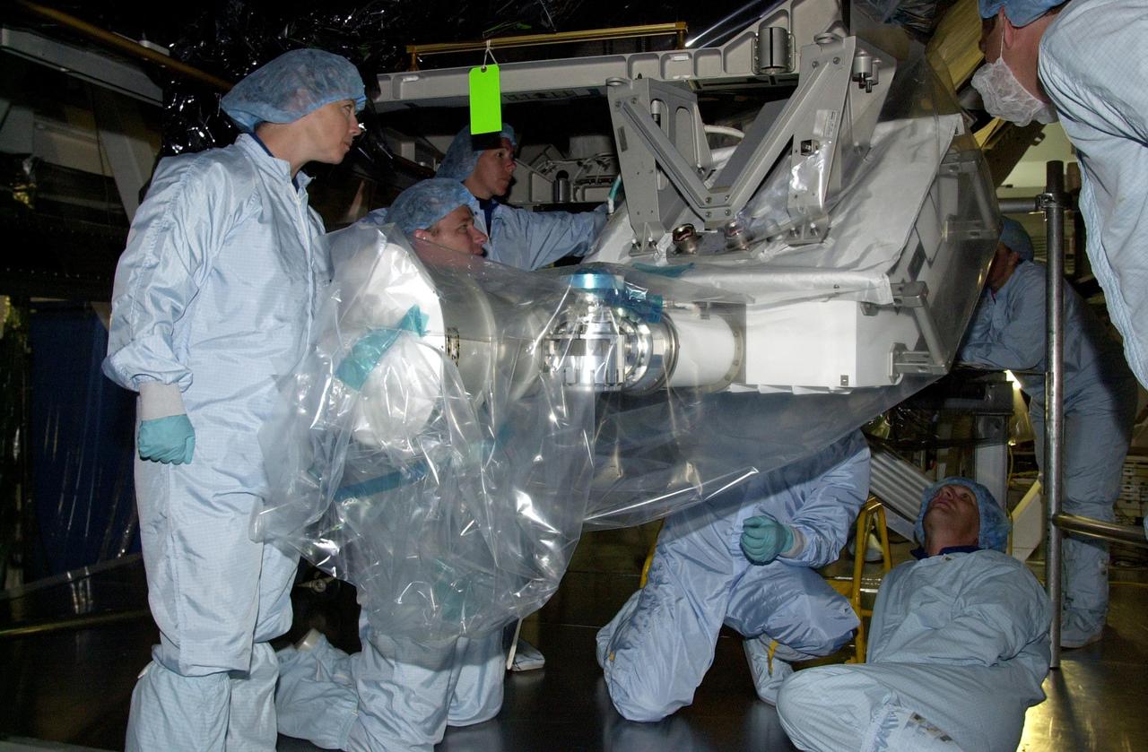 KENNEDY SPACE CENTER, FLA. -- As part of the Crew Equipment Interface Test, members of the STS-112 crew look at the S1 Integrated Truss Structure, part of the payload for their mission to the International Space Station. From left are Pilot Pamela Melroy and Mission Specialists Piers Sellers and Sandra Magnus. At right, looking up, is Commander Jeffrey Ashby. The S1 truss is the first starboard (right-side) truss segment, whose main job is providing structural support for the orbiting research facility's radiator panels that cool the Space Station's complex power system. The S1 truss segment also will house communications systems, external experiment positions and other subsystems. The S1 truss will be attached to the S0 truss. Launch of STS-112 is scheduled for Aug. 22, 2002