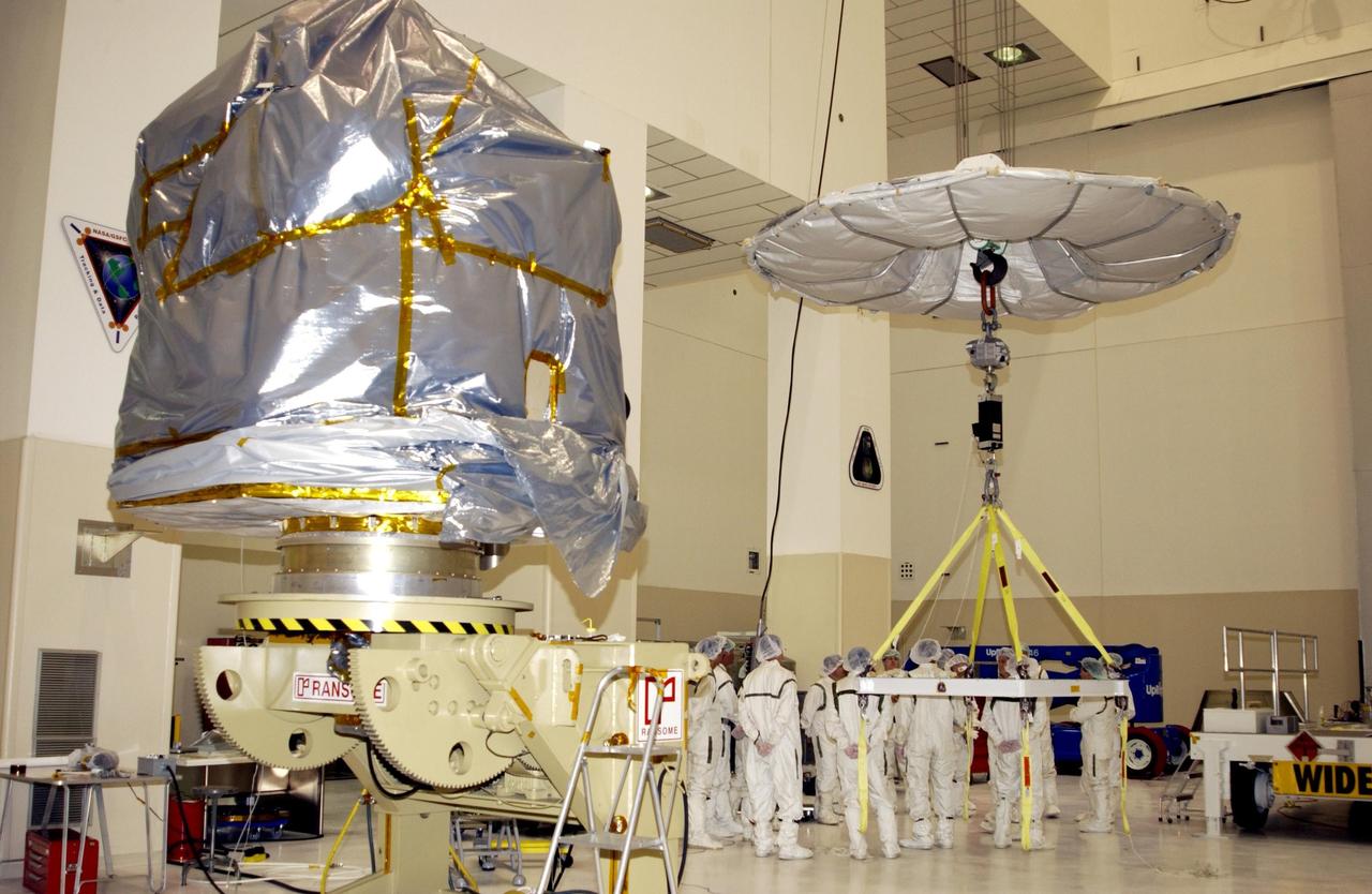 KENNEDY SPACE CENTER, FLA. -- In the Space Assembly and Encapsulation Facility 2 (SAEF-2), the Comet Nucleus Tour (CONTOUR) spacecraft (left) is wrapped and ready for the crane at right to carry it to the upper stage of a Boeing Delta II rocket for mating. CONTOUR will provide the first detailed look into the heart of a comet -- the nucleus. Flying as close as 60 miles (100 kilometers) to at least two comets, the spacecraft will take the sharpest pictures yet of a nucleus while analyzing the gas and dust that surround these rocky, icy building blocks of the solar system. Launch of CONTOUR aboard the Delta II is scheduled for July 1, 2002, from Launch Complex 17-A, Cape Canaveral Air Force Station