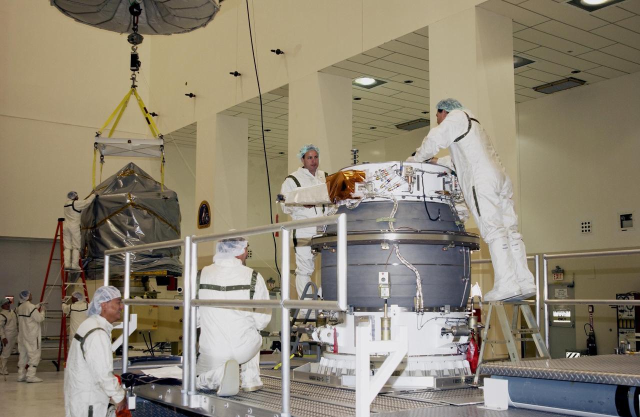 KENNEDY SPACE CENTER, FLA. -- In the Space Assembly and Encapsulation Facility 2 (SAEF-2), workers at right prepare the upper stage of a Boeing Delta II rocket for mating with the Comet Nucleus Tour (CONTOUR) spacecraft at left. CONTOUR will provide the first detailed look into the heart of a comet -- the nucleus. Flying as close as 60 miles (100 kilometers) to at least two comets, the spacecraft will take the sharpest pictures yet of a nucleus while analyzing the gas and dust that surround these rocky, icy building blocks of the solar system. Launch of CONTOUR aboard the Delta II is scheduled for July 1, 2002, from Launch Complex 17-A, Cape Canaveral Air Force Station