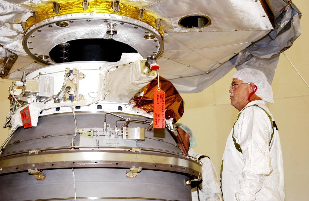 KENNEDY SPACE CENTER, FLA. --  As the Comet Nucleus Tour (CONTOUR) spacecraft is lowered toward the upper stage of a Boeing Delta II rocket, a worker keeps close watch.  The two components are being mated for launch. CONTOUR will provide the first detailed look into the heart of a comet -- the nucleus. Flying as close as 60 miles (100 kilometers) to at least two comets, the spacecraft will take the sharpest pictures yet of a nucleus while analyzing the gas and dust that surround these rocky, icy building blocks of the solar system.  Launch of CONTOUR aboard the Delta II is scheduled for July 1, 2002, from Launch Complex 17-A, Cape Canaveral Air Force Station