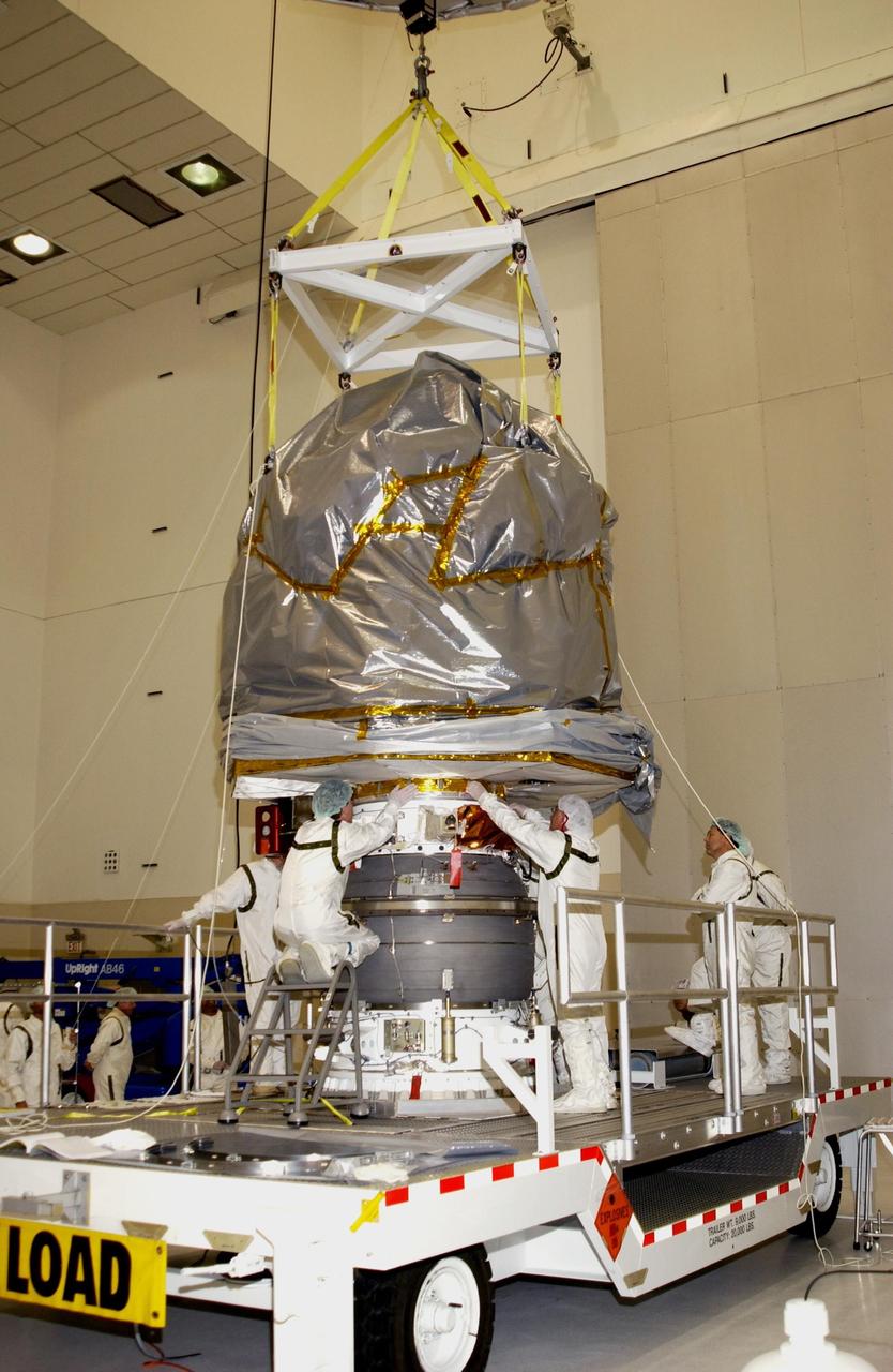 KENNEDY SPACE CENTER, FLA. -- Workers help guide the Comet Nucleus Tour (CONTOUR) spacecraft as it is lowered onto the upper stage of a Boeing Delta II rocket for mating. CONTOUR will provide the first detailed look into the heart of a comet -- the nucleus. Flying as close as 60 miles (100 kilometers) to at least two comets, the spacecraft will take the sharpest pictures yet of a nucleus while analyzing the gas and dust that surround these rocky, icy building blocks of the solar system.  Launch of CONTOUR aboard the Delta II is scheduled for July 1, 2002, from Launch Complex 17-A, Cape Canaveral Air Force Station