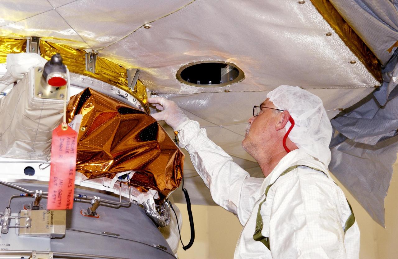 KENNEDY SPACE CENTER, FLA. -- A worker checks the fit as the Comet Nucleus Tour (CONTOUR) spacecraft is mated to the upper stage of a Boeing Delta II rocket.  CONTOUR will provide the first detailed look into the heart of a comet -- the nucleus. Flying as close as 60 miles (100 kilometers) to at least two comets, the spacecraft will take the sharpest pictures yet of a nucleus while analyzing the gas and dust that surround these rocky, icy building blocks of the solar system.  Launch of CONTOUR aboard the Delta II is scheduled for July 1, 2002, from Launch Complex 17-A, Cape Canaveral Air Force Station