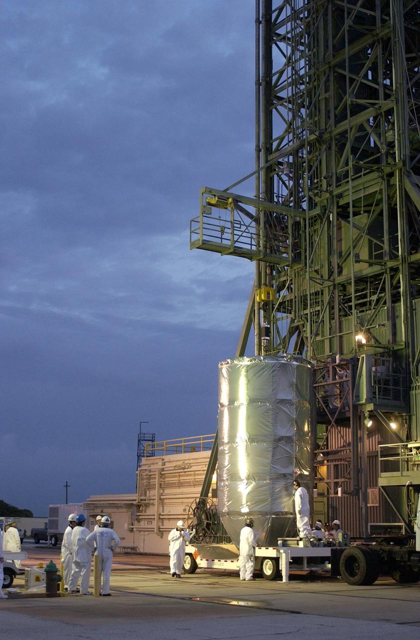 KENNEDY SPACE CENTER, FLA. -- On Launch Complex 17-A, Cape Canaveral Air Force Station, workers attach a crane to the top of the canister containing the Comet Nucleus Tour (CONTOUR) spacecraft. CONTOUR will be lifted up the gantry for encapsulation and mating with the launch vehicle. CONTOUR will provide the first detailed look into the heart of a comet -- the nucleus. Flying as close as 60 miles (100 kilometers) to at least two comets, the spacecraft will take the sharpest pictures yet of a nucleus while analyzing the gas and dust that surround these rocky, icy building blocks of the solar system. Launch of CONTOUR aboard a Boeing Delta II rocket is scheduled for July 1, 2002