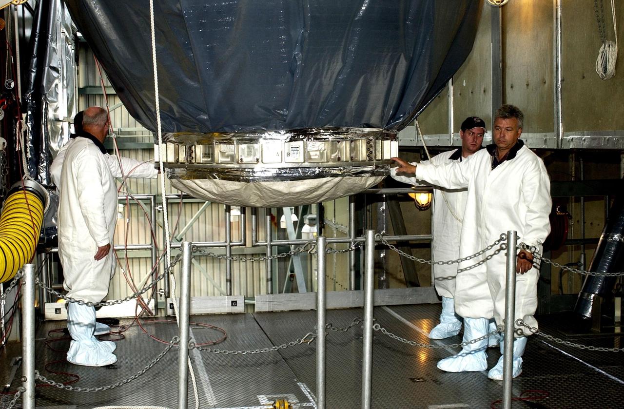 KENNEDY SPACE CENTER, FLA. --  Workers on the launch tower at Launch Complex 17-A, Cape Canaveral Air Force Station, steady the Comet Nucleus Tour (CONTOUR) spacecraft before it is moved to the launch vehicle. CONTOUR will provide the first detailed look into the heart of a comet -- the nucleus. Flying as close as 60 miles (100 kilometers) to at least two comets, the spacecraft will take the sharpest pictures yet of a nucleus while analyzing the gas and dust that surround these rocky, icy building blocks of the solar system.  Launch of CONTOUR aboard a Boeing Delta II rocket is scheduled for July 1, 2002