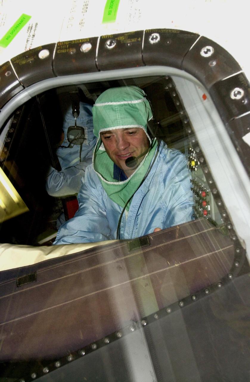 KENNEDY SPACE CENTER, FLA. -- During a Crew Equipment Interface Test, STS-112 Commander Jeffrey Ashby checks out the windshield on Atlantis, the designated orbiter for the mission. STS-112 is the 15th assembly flight to the International Space Station and will be ferrying the S1 Integrated Truss Structure. The S1 truss is the first starboard (right-side) truss segment, whose main job is providing structural support for the radiator panels that cool the Space Station's complex power system. The S1 truss segment also will house communications systems, external experiment positions and other subsystems. The S1 truss will be attached to the S0 truss. STS-112 is currently scheduled for launch Aug. 22, 2002