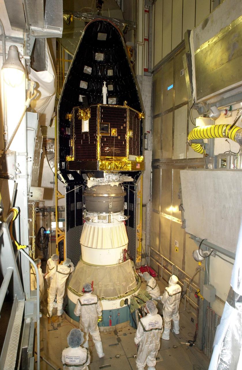 KENNEDY SPACE CENTER, FLA. -- At Launch Complex 17-A, Cape Canaveral Air Force Station, the first part of the fairing is moved into place around the Comet Nucleus Tour (CONTOUR) spacecraft.  The fairing is the outer cover that protects the spacecraft during launch. Below the spacecraft is the Delta II rocket, the launch vehicle.  CONTOUR will provide the first detailed look into the heart of a comet -- the nucleus. Flying as close as 60 miles (100 kilometers) to at least two comets, the spacecraft will take the sharpest pictures yet of a nucleus while analyzing the gas and dust that surround them.  Launch of CONTOUR is scheduled for July 1, 2002