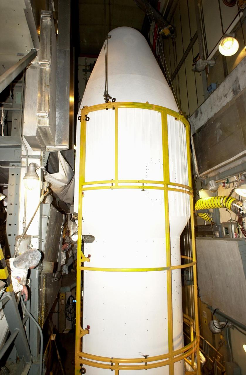 KENNEDY SPACE CENTER, FLA. -- At Launch Complex 17-A, Cape Canaveral Air Force Station,  workers watch as the second half of the fairing moves toward the Comet Nucleus Tour (CONTOUR).  The fairing is the outer cover that protects the spacecraft during launch. Below the spacecraft is the Delta II rocket, the launch vehicle.  CONTOUR will provide the first detailed look into the heart of a comet -- the nucleus. Flying as close as 60 miles (100 kilometers) to at least two comets, the spacecraft will take the sharpest pictures yet of a nucleus while analyzing the gas and dust that surround them.  Launch of CONTOUR is scheduled for July 1, 2002