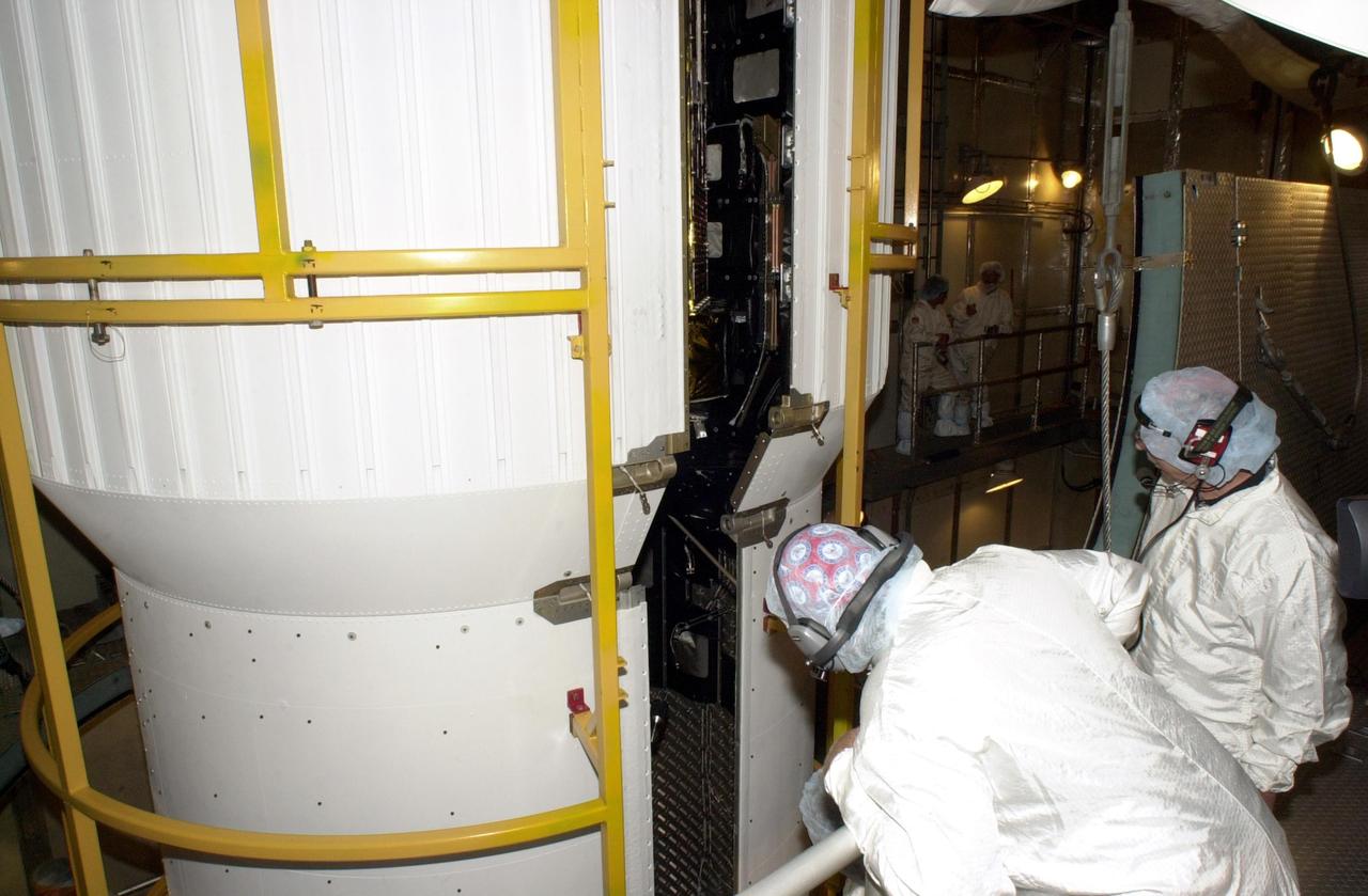 KENNEDY SPACE CENTER, FLA. -- At Launch Complex 17-A, Cape Canaveral Air Force Station,  workers watch as the two halves of the fairing move closer together, encircling the Comet Nucleus Tour (CONTOUR).  The fairing is the outer cover that protects the spacecraft during launch. Below the spacecraft is the Delta II rocket, the launch vehicle.  CONTOUR will provide the first detailed look into the heart of a comet -- the nucleus. Flying as close as 60 miles (100 kilometers) to at least two comets, the spacecraft will take the sharpest pictures yet of a nucleus while analyzing the gas and dust that surround them.  Launch of CONTOUR is scheduled for July 1, 2002