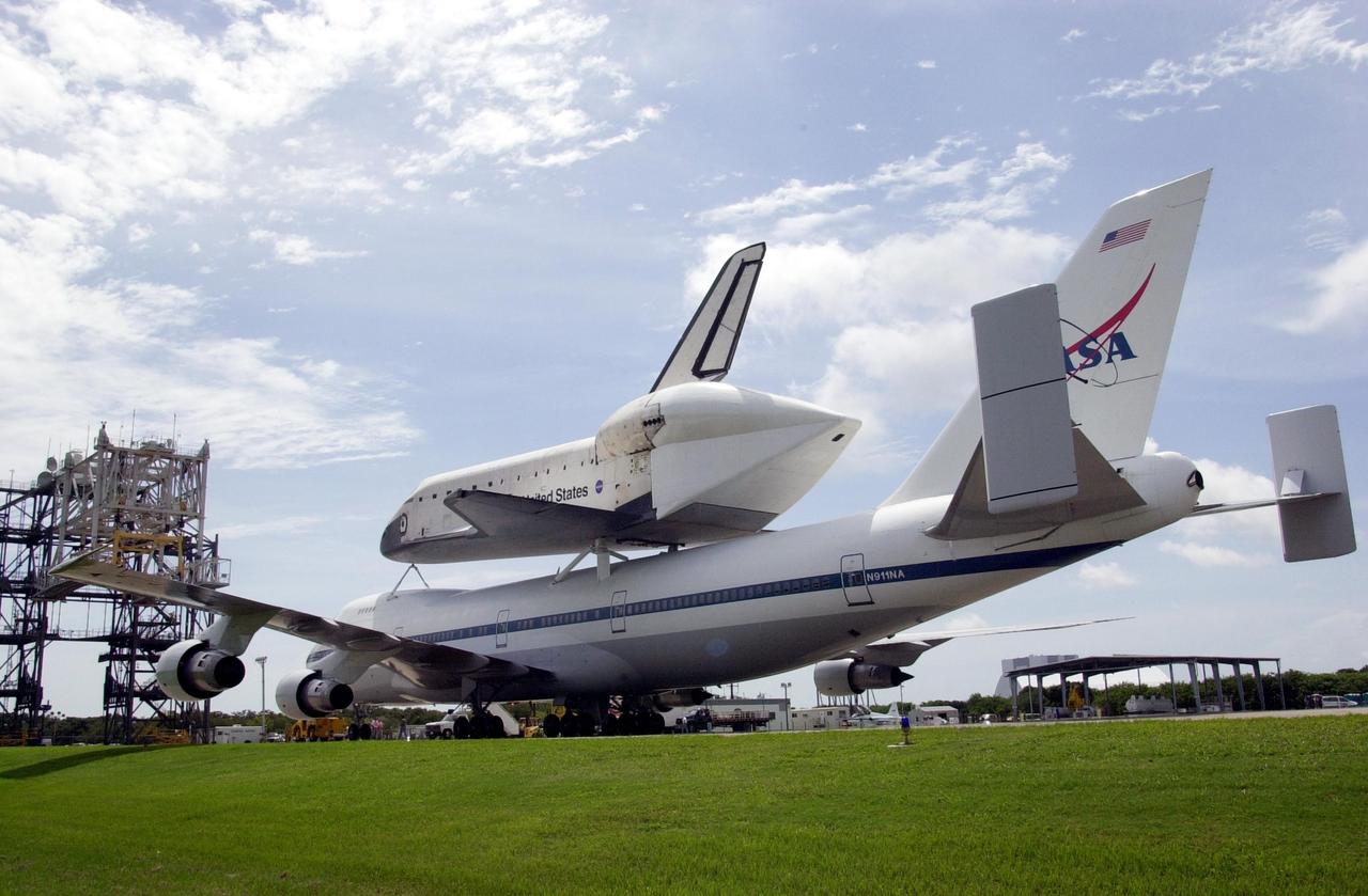KENNEDY SPACE CENTER, FLA. - Space Shuttle Endeavour approaches the Mate-Demate Device (left) following landing on runway 15 at KSC's Shuttle Landing Facility at 10:58 a.m. EDT atop a modified Boeing 747 Shuttle Carrier Aircraft.  The cross-country ferry flight became necessary when three days of unfavorable weather conditions at KSC forced Endeavour to land on runway 22 at Dryden Flight Research Center, Edwards Air Force Base, Calif., on June 19 following mission STS-111.  Processing of Endeavour will now begin for the launch of mission STS-113 targeted for October 2002