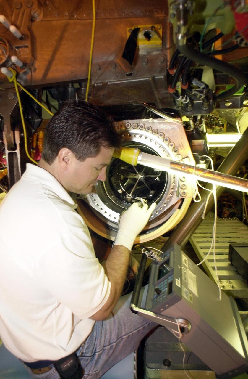 KENNEDY SPACE CENTER, FLA. --  Ken Tauer, with United Space Alliance, inspects the flow line on Columbia after the engines were removed.  The inspection is the result of small cracks being discovered on the LH2 Main Propulsion System (MPS) flow liners in two other orbiters.  Program managers decided to conduct inspections on Columbia before clearing it for flight on STS-107. The July 19 launch of Columbia on STS-107 has been delayed a few weeks
