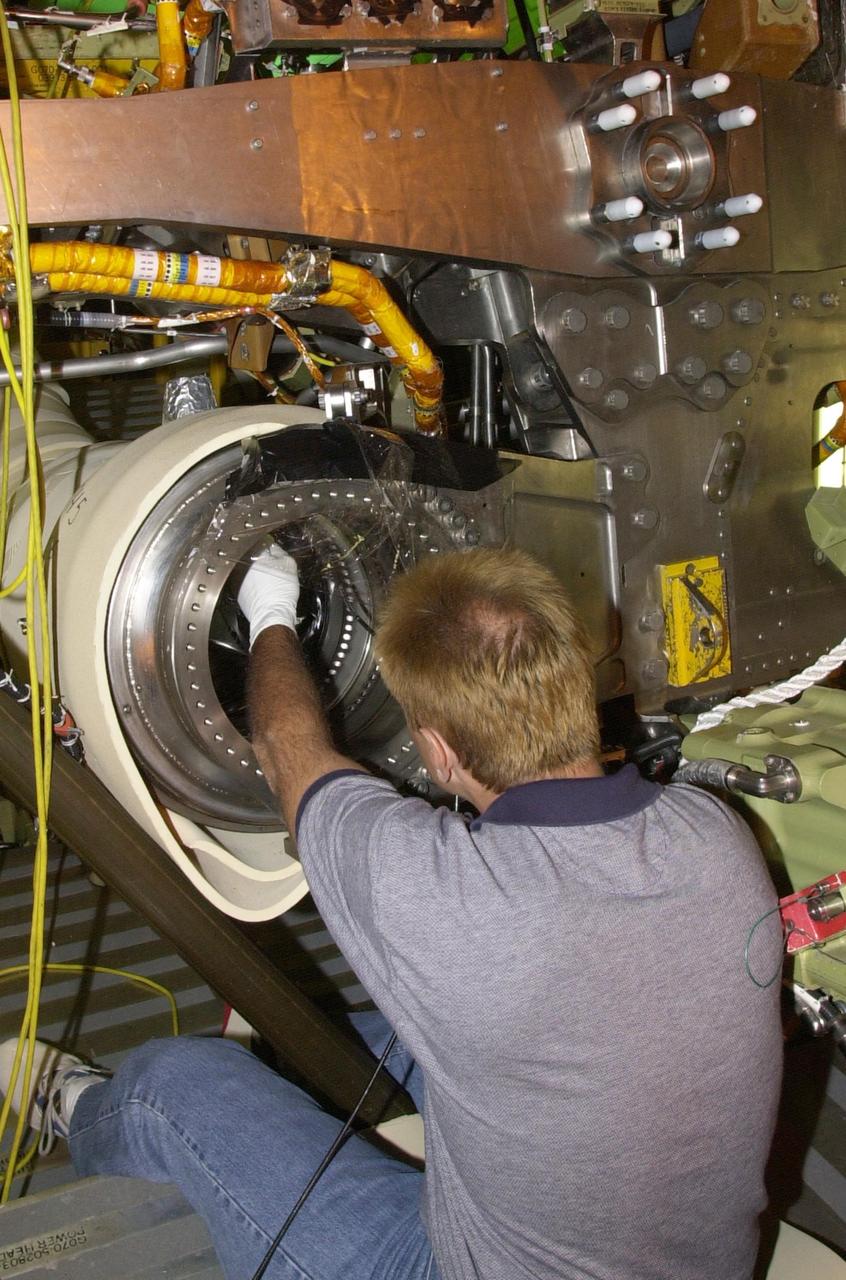 KENNEDY SPACE CENTER, FLA. - Tim Appleby, with United Space Alliance, inspects the flow line on Columbia after the engines were removed.  The inspection is the result of small cracks being discovered on the LH2 Main Propulsion System (MPS) flow liners in two other orbiters.  Program managers decided to conduct inspections on Columbia before clearing it for flight on STS-107. The July 19 launch of Columbia on STS-107 has been delayed a few weeks