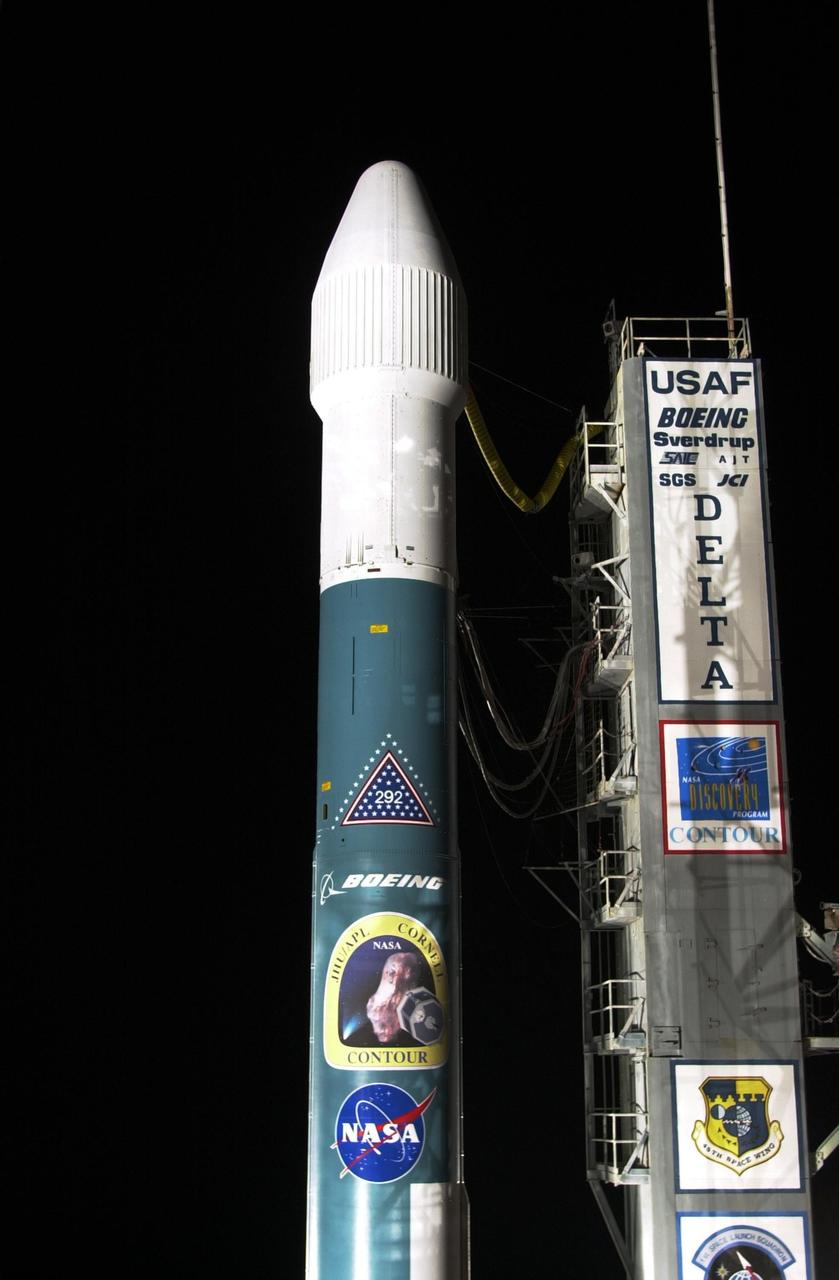 KENNEDY SPACE CENTER, FLA. -- After tower rollback, the Boeing Delta II rocket with NASA's Comet Nucleus Tour (CONTOUR) spacecraft attached is visible. The rocket exhibits several logos, including that of CONTOUR, Boeing and NASA. The launch is scheduled for 2:47 a.m. EDT July 3. Designed and built by The Johns Hopkins University Applied Physics Laboratory (APL) in Laurel, Md., the 2,138-pound (970-kilogram) spacecraft will be placed into an elliptical Earth orbit until Aug. 15, when it is scheduled to fire its main engine and enter a comet-chasing orbit around the sun. The mission's flexible four-year plan includes encounters with comets Encke (Nov. 12, 2003) and Schwassmann-Wachmann 3 (June 19, 2006), though it can add an encounter with a "new" and scientifically valuable comet from the outer solar system, should one be discovered in time for CONTOUR to fly past it. CONTOUR's four scientific instruments will take detailed pictures and measure the chemical makeup of each comet's nucleus -- a chunk of ice and rock -- while analyzing the surrounding gas and dust.