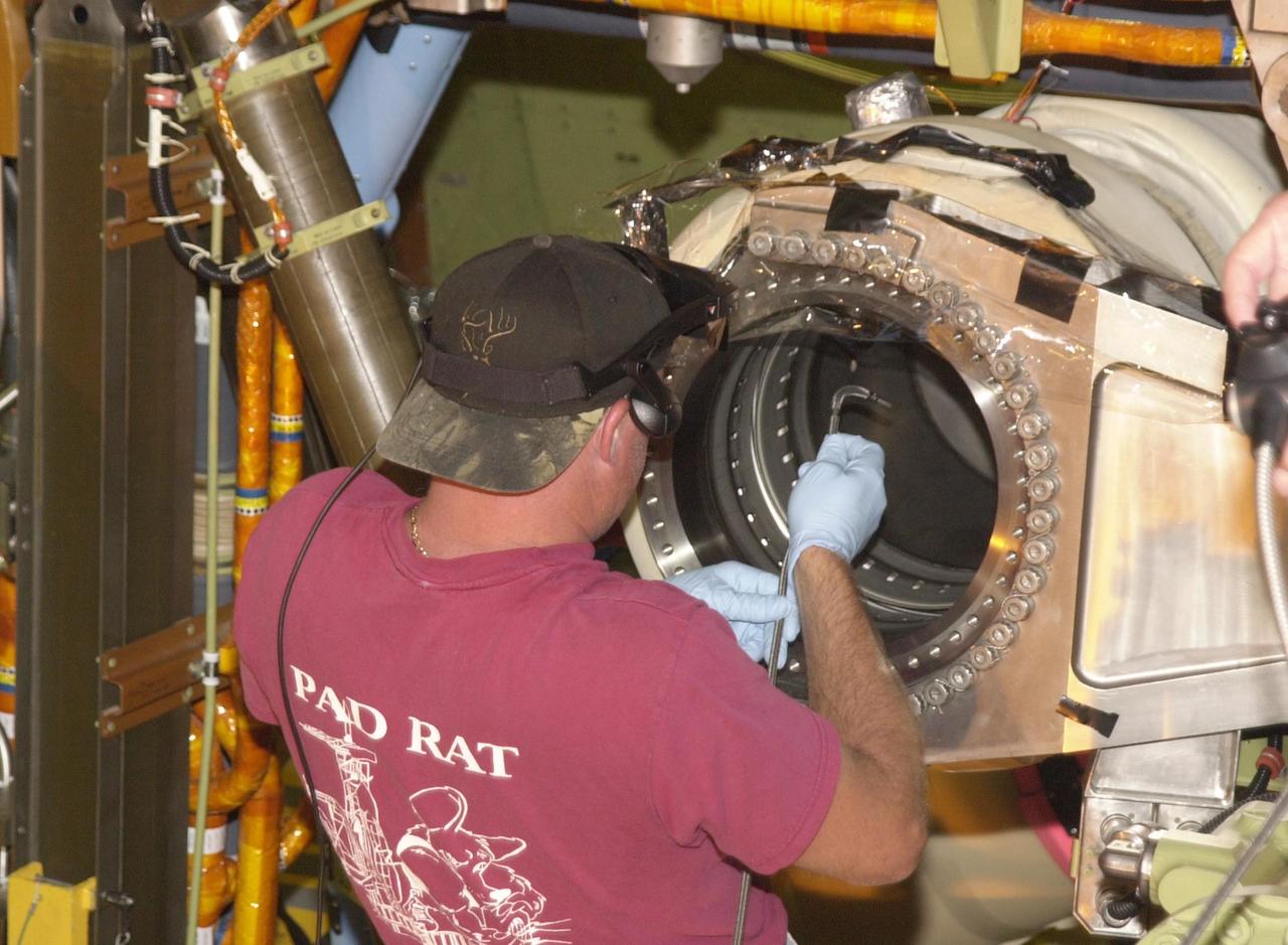 KENNEDY SPACE CENTER, FLA. -- Scott Minnick, with United Space Alliance, places a fiber-optic camera inside the flow line on Endeavour. Minnick wears a special viewing apparatus that sees where the camera is going. The inspection is the result of small cracks being discovered on the LH2 Main Propulsion System (MPS) flow liners in other orbiters. Endeavour is next scheduled to fly on mission STS-113.