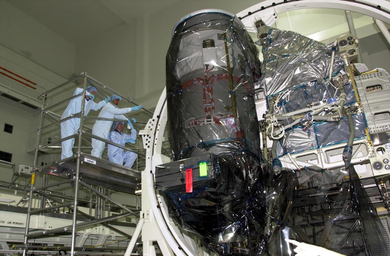 KENNEDY SPACE CENTER, FLA. -- During Crew Equipment Interface Test (CEIT), STS-116 Mission Specialist Christer Fugelsang, with the European Space Agency, Mission Specialist Robert Curbeam and Pilot William Oelefein look over equipment they will be working with during their mission to the International Space Station. The 19th assembly flight to the ISS, the mission will deliver the third port truss segment, the P5 Truss, to attach to second port truss segment, the P3/P4 Truss, to be assembled in an earlier mission.  STS-116 is scheduled for launch in June 2003.                        