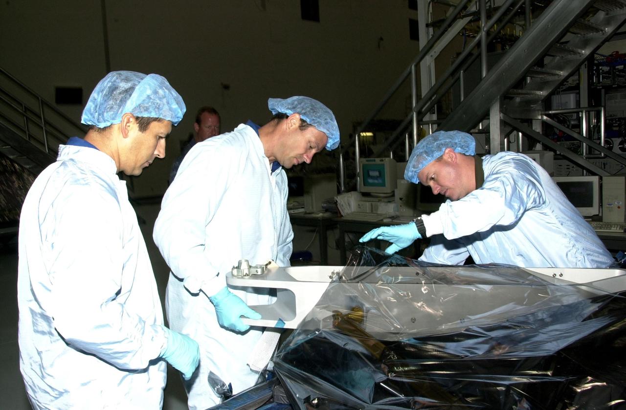 KENNEDY SPACE CENTER, FLA. --STS-113 Mission Specialists John Herrington (left) and Michael Lopez-Alegria (center) look over equipment involved in their mission during Crew Equipment Interface Test activities in the Space Station Processing Facility. Part of the payload on mission STS-113 is the first port truss segment, P1 Truss, to be attached to the central truss segment, S0, on the International Space Station. Once delivered, the P1 truss will remain stowed until flight 12A.1. Launch date for STS-113 is under review.